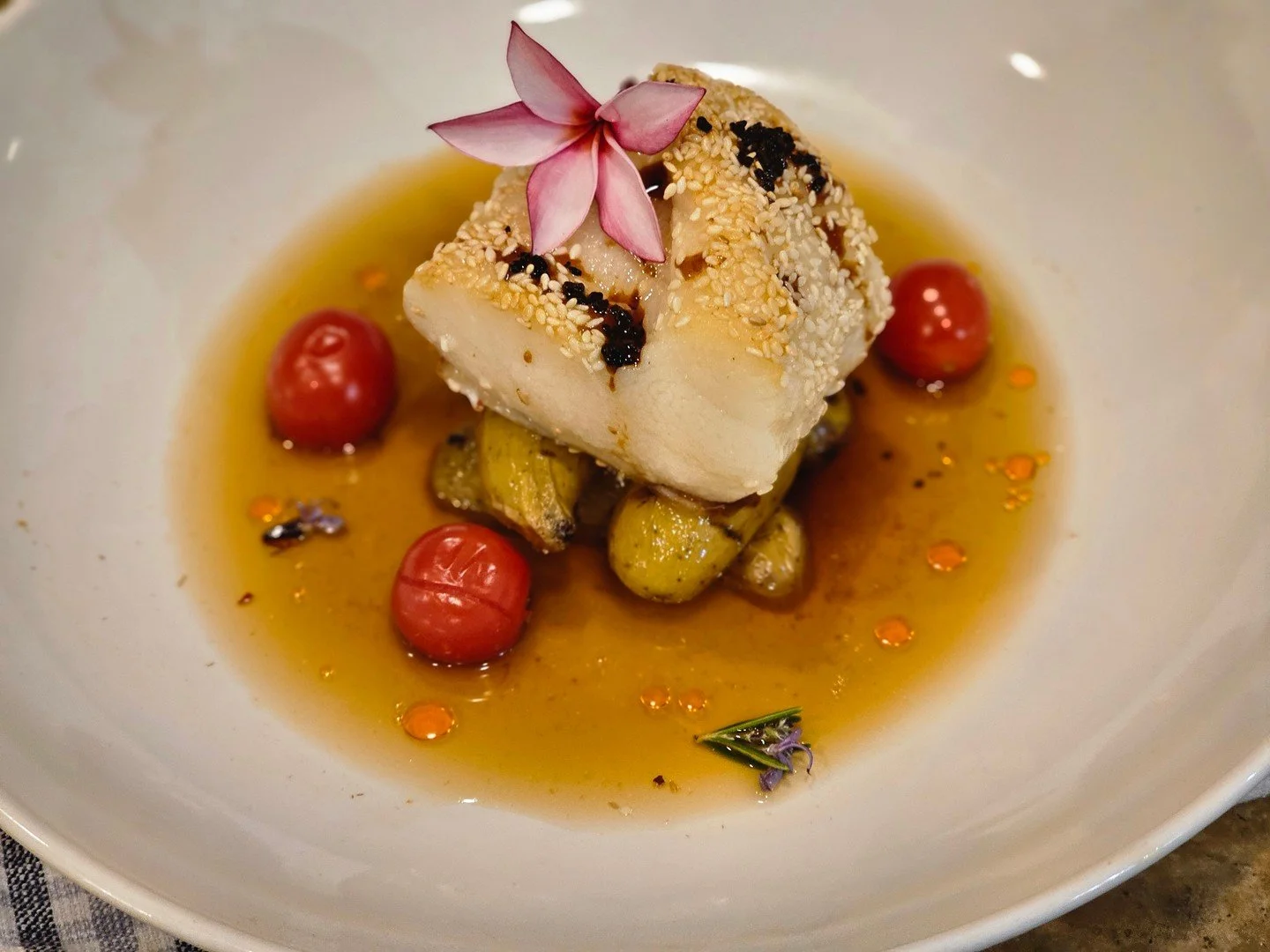 This isn&rsquo;t just dinner&mdash;it&rsquo;s edible art. A sesame-crusted white fish resting on blistered cherry tomatoes and golden potatoes, finished with rosemary-infused broth and a hint of chili oil. Every bite? Balanced. Every detail? Designed