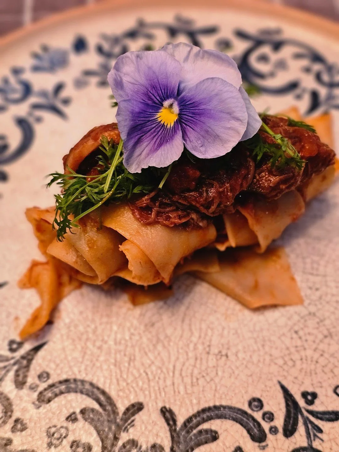Melt-in-your-mouth short rib over silky fresh pappardelle&mdash;because no one&rsquo;s sticking to resolutions just yet.
Finished with fresh herbs and edible blooms for that extra wow.

💫 Want this at your next dinner party? We&rsquo;ll bring the ch