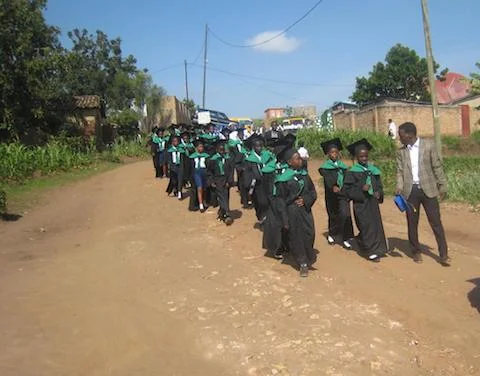 Primary 6 graduated, pictured with the Primary English teacher, Ignace.