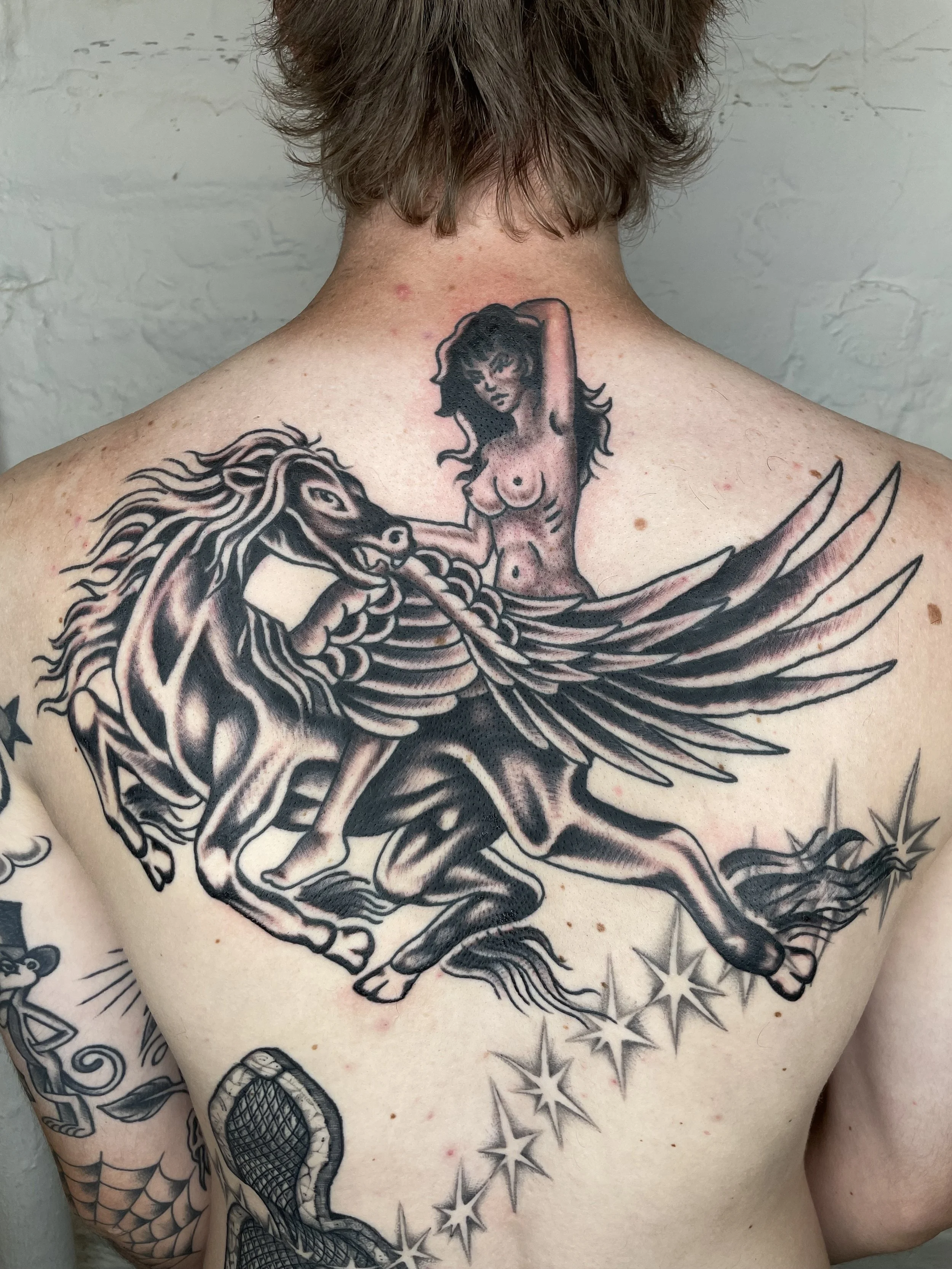 flying horse with a girl riding tattoo on the back