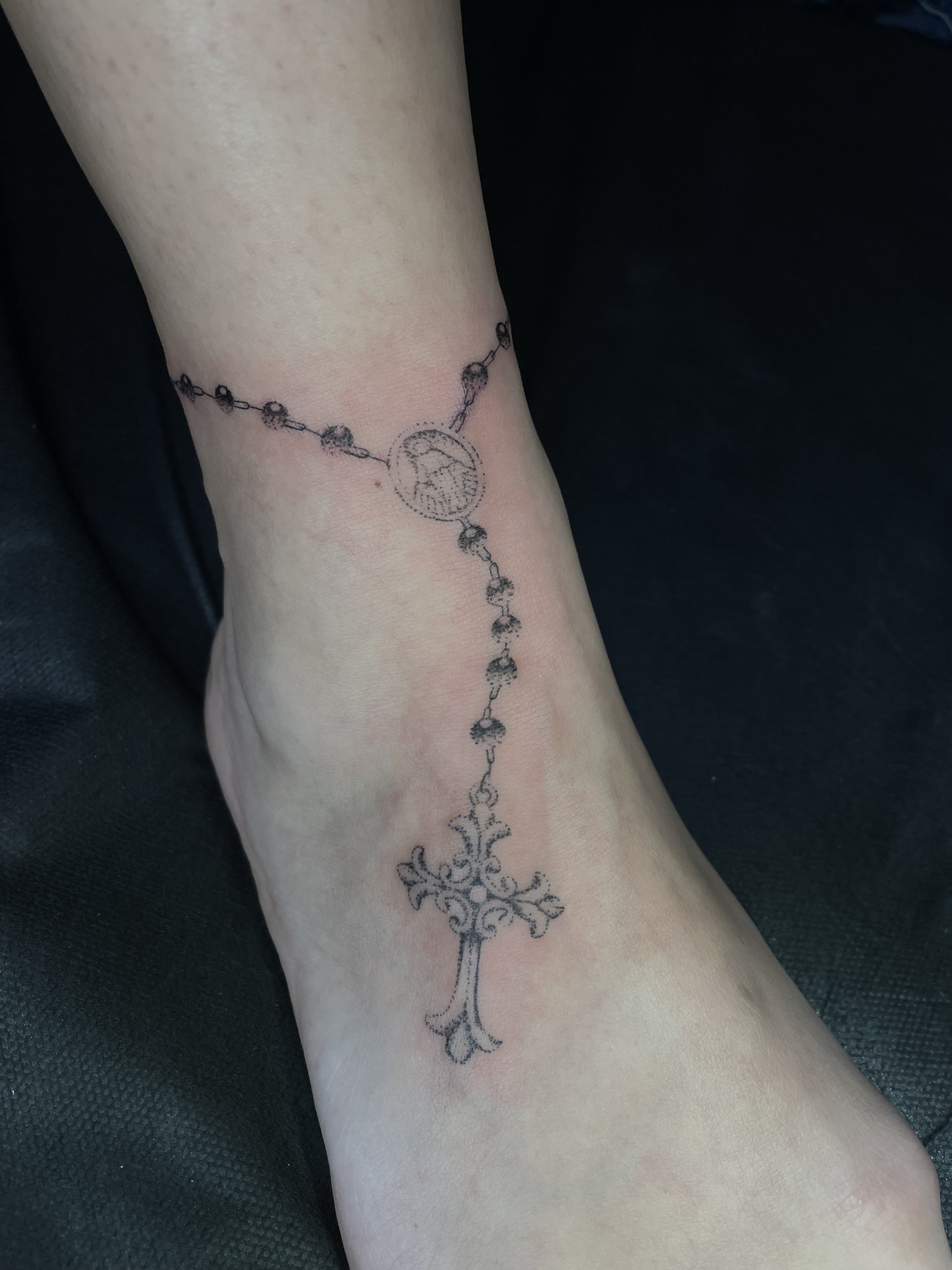 blackwork rosary tattoo on ankle.jpeg