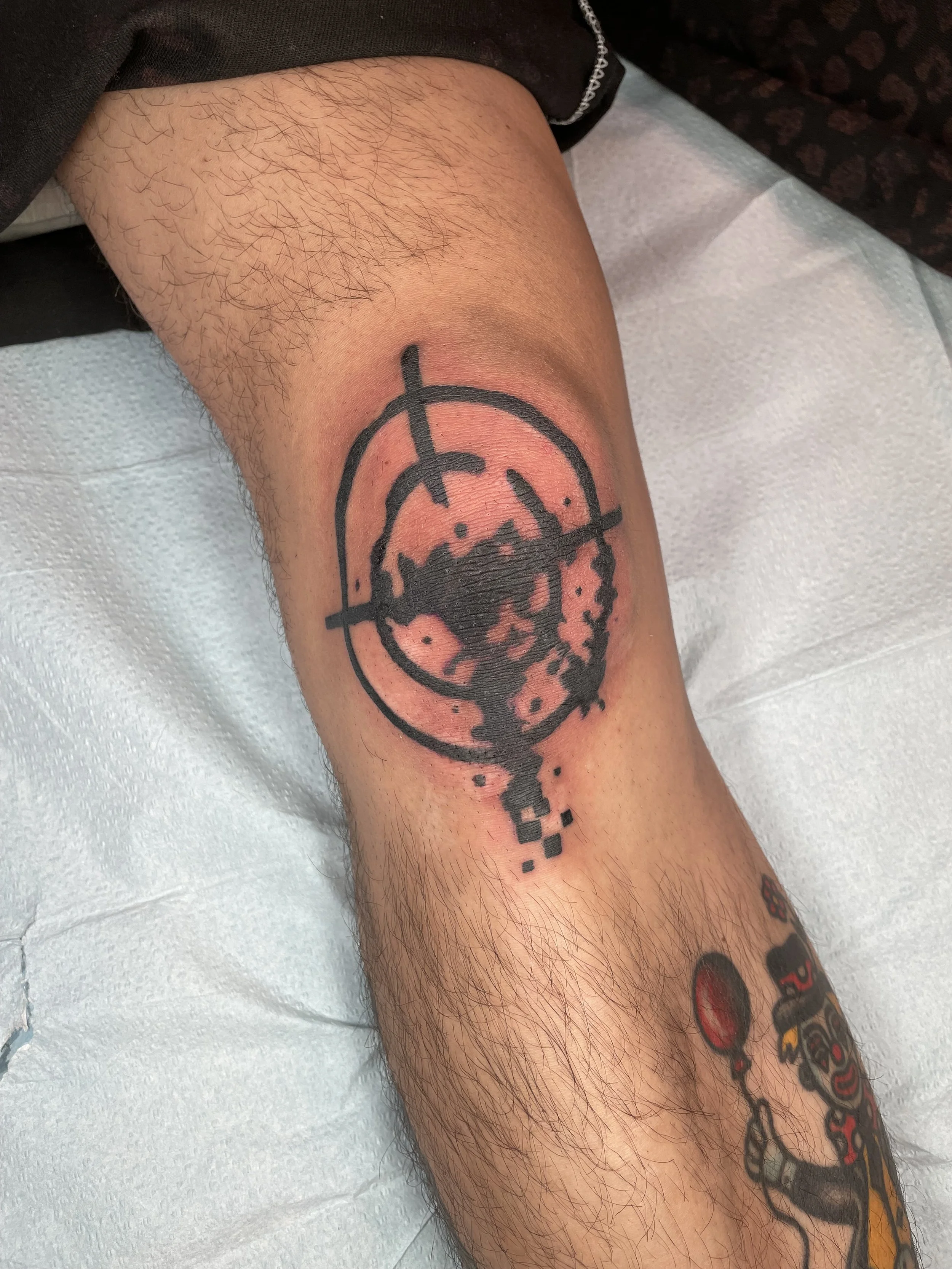 blackwork scope on knee tattoo.jpeg