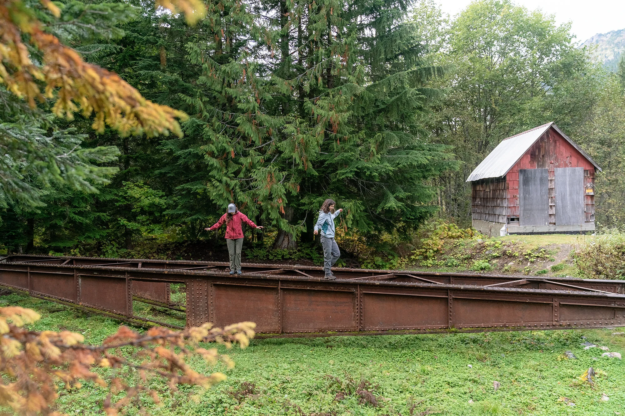 A photo by Mark McInnis of two people balancing on a metal structure wearing Outdoor Research jackets.