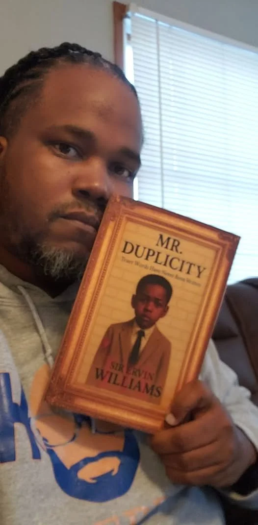 DEREK HOLDING BOOK.jpg