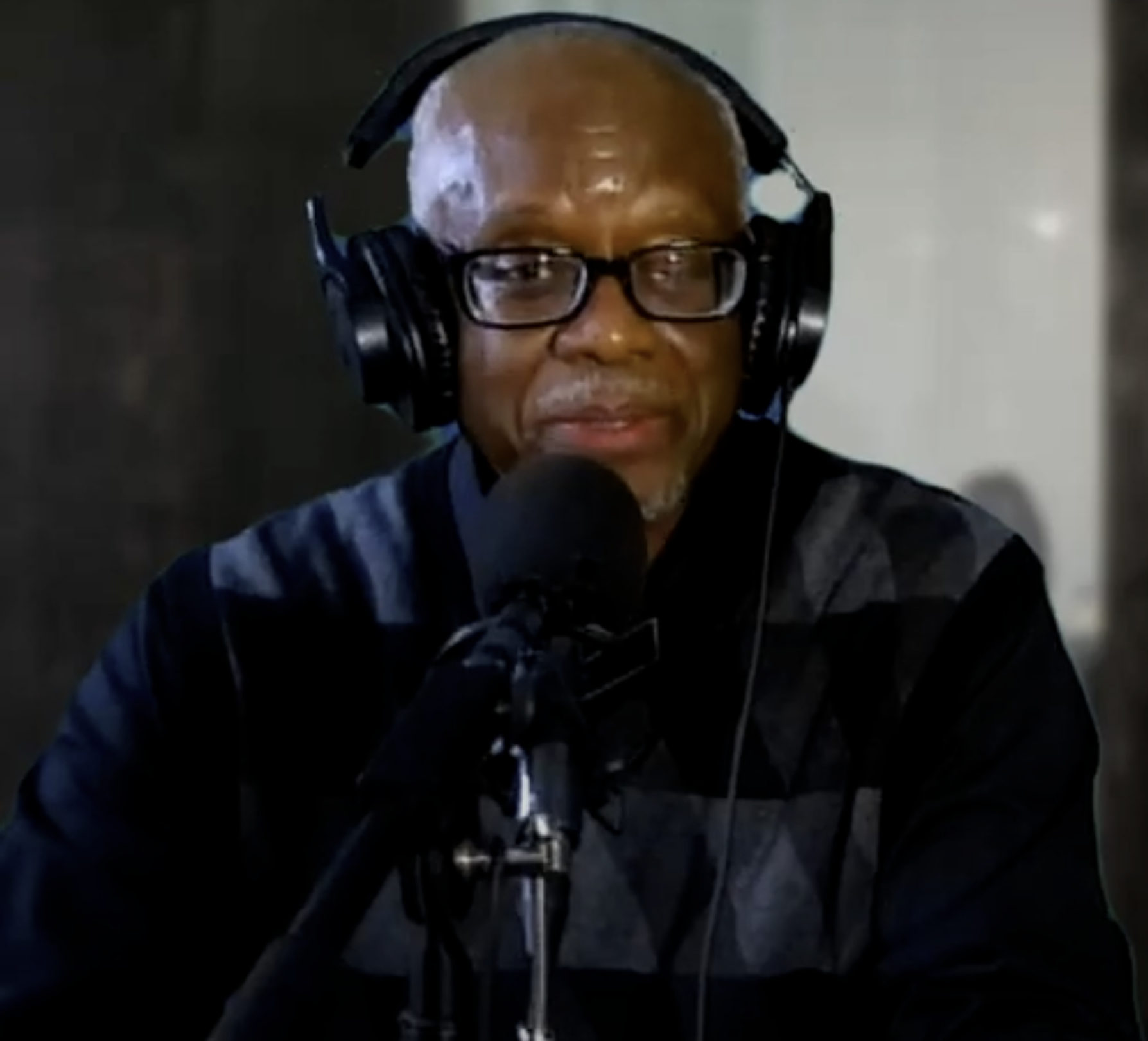 Man wearing headphones speaking into a microphone