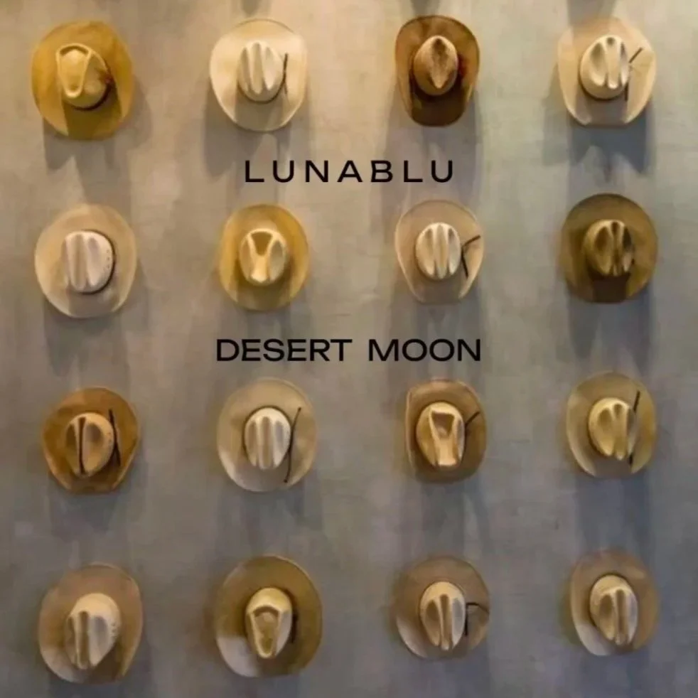 Wall display of 15 cowboy hats arranged in a 3x5 grid with the text 'LUNABLU' above and 'DESERT MOON' below.