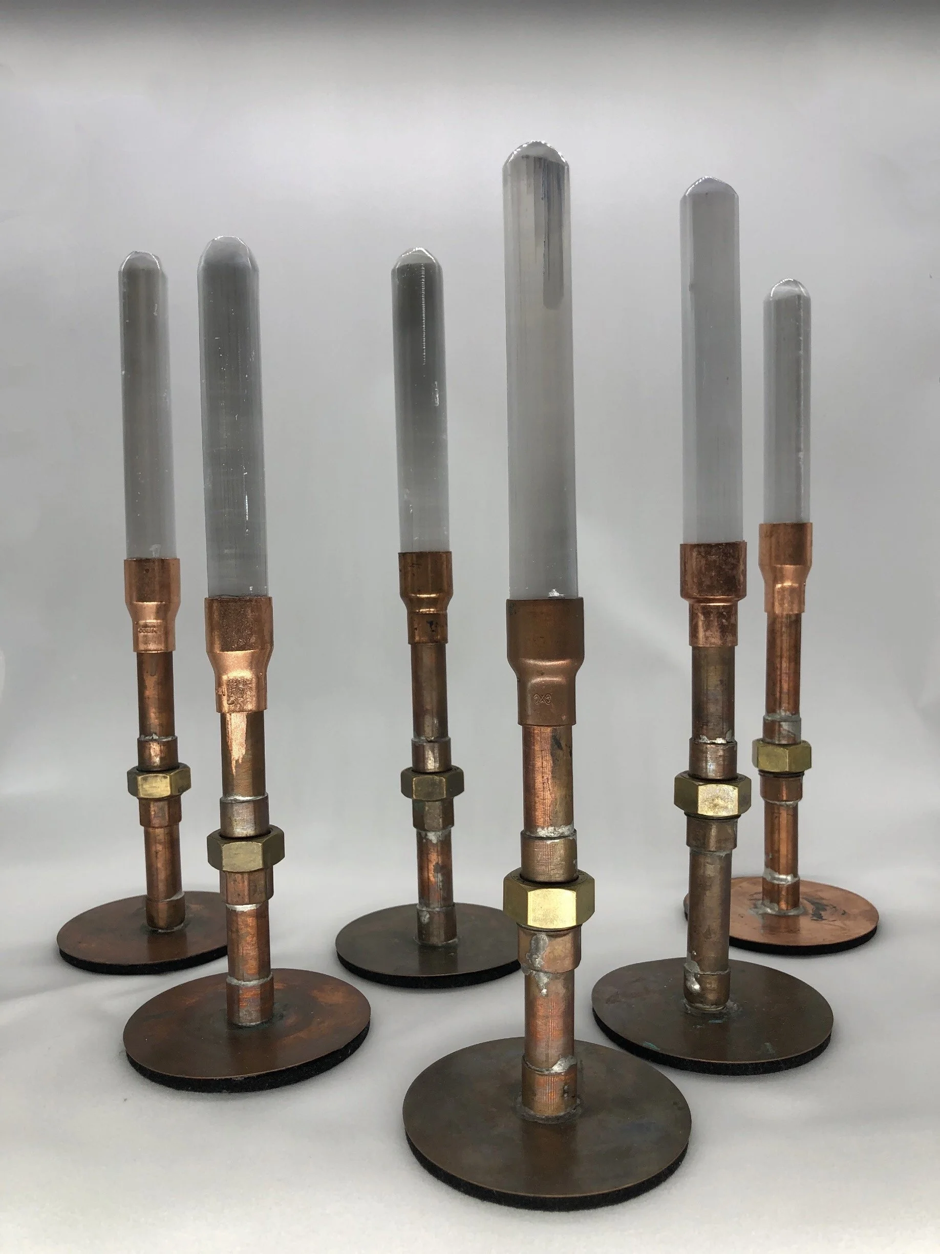 Seven copper and metal conductive probes mounted on round bases, organized in a row.