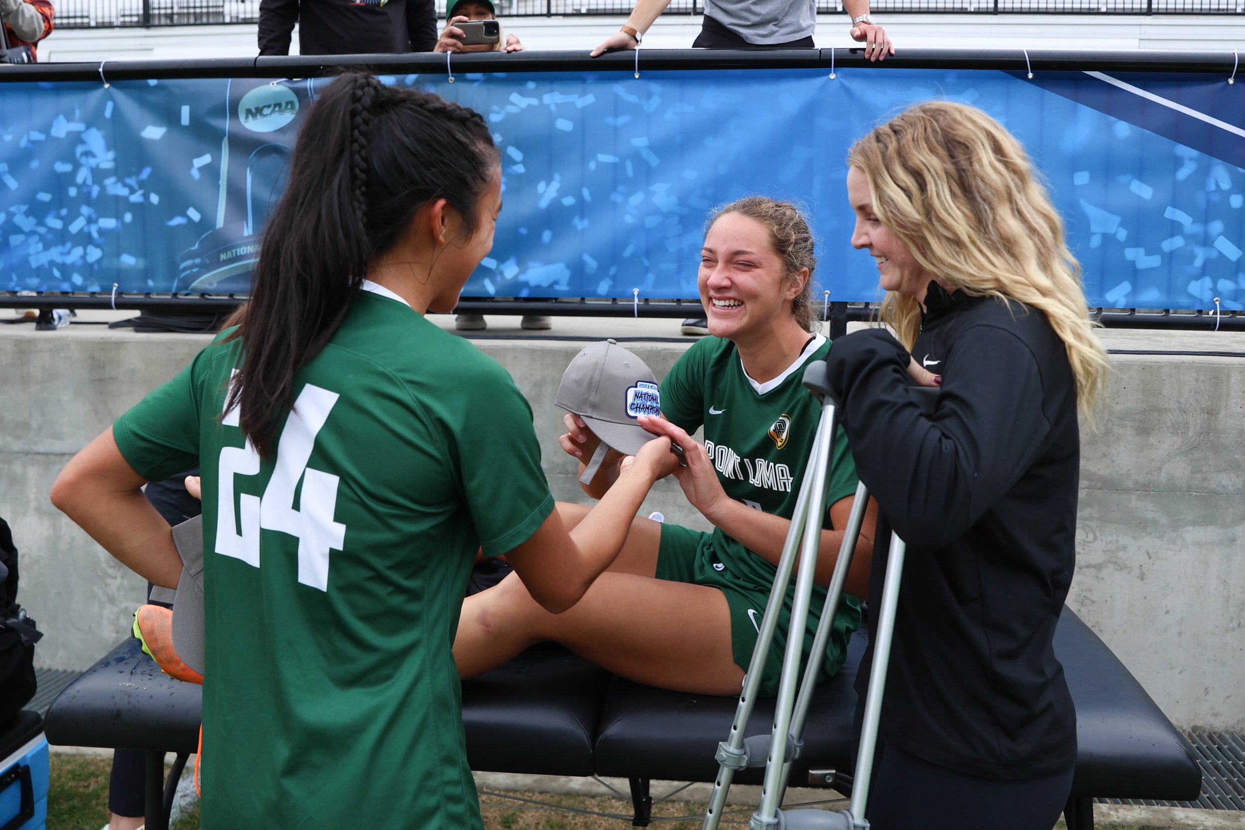  MATTHEWS, NORTH CAROLINA - DECEMBER 9: Bethany Arabe #24 gives Jensen Shrout #5 of the Point Loma Sea Lions a championship hat as they celebrate defeating the Washburn Ichabods during the Division II Women's Soccer Championship held at Sportsplex Ma