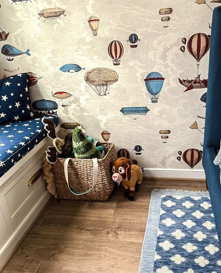 We've been working on this sweet boy's bedroom:  creating a custom built-in window seat in a neglected nook, complete with cushions adorned in a starry fabric, wallpapering the plain white walls in a whimsical pattern, and installing a stunning navy 