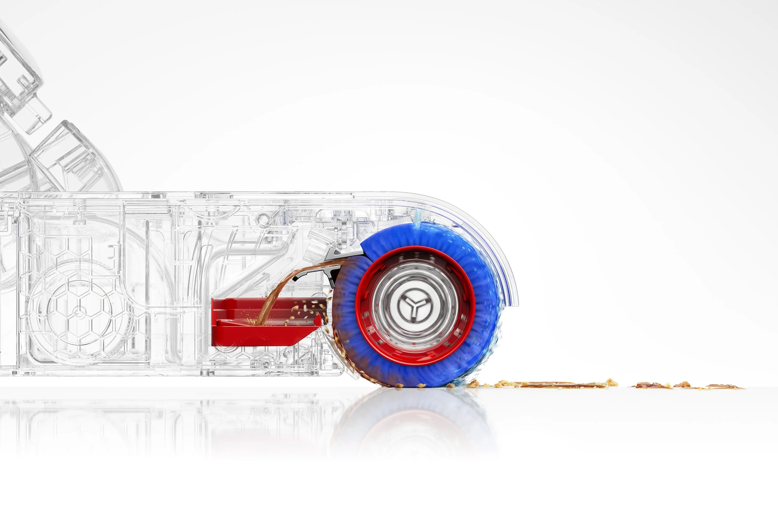 Close-up of a transparent, glass effect, Dyson vacuum cleaner in motion, with a blue brushbar, cleaning debris off a white surface against a plain background. Showing the path of debris from floor into debris tray.