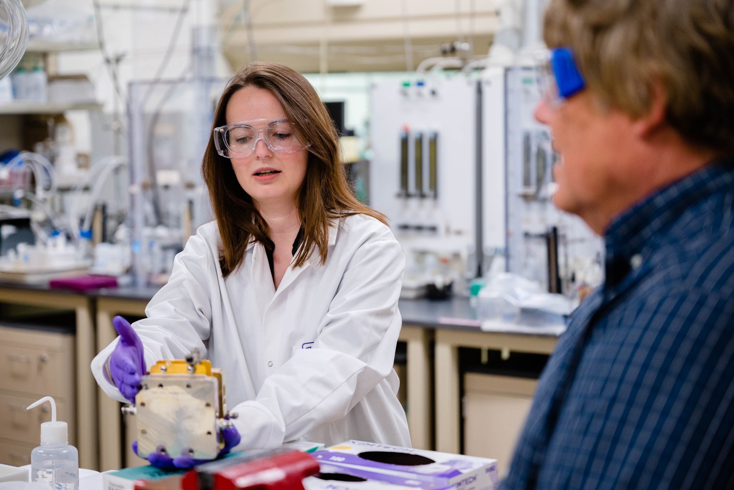 Karin Calvinho explaining lab-scale CO2 electrolyzer and Ted Krause - Courtesy of Argonne National Lab.jpg