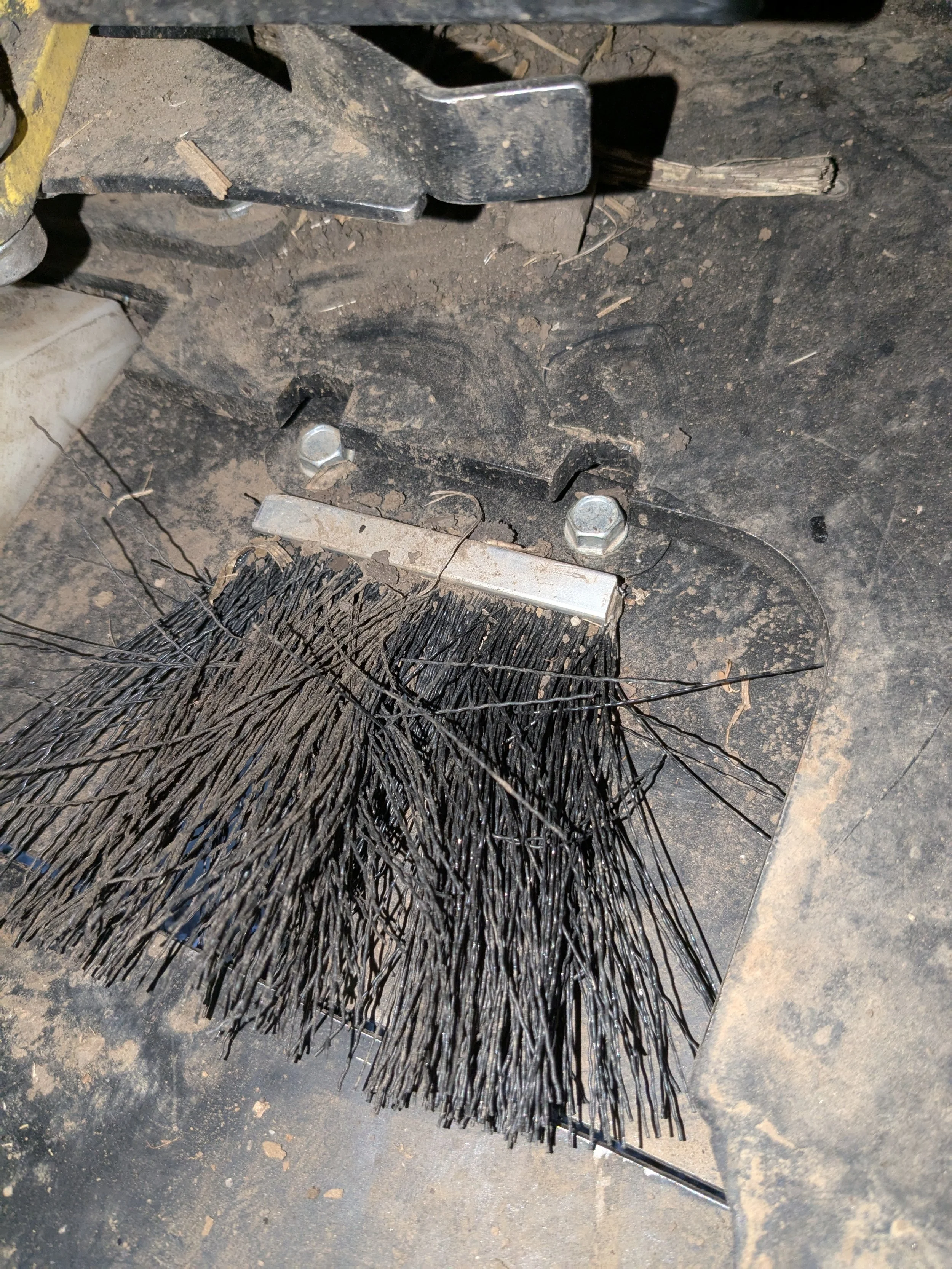 Close-up of a broom with black bristles Cleaning dirt and debris from a mechanical equipment or machinery.