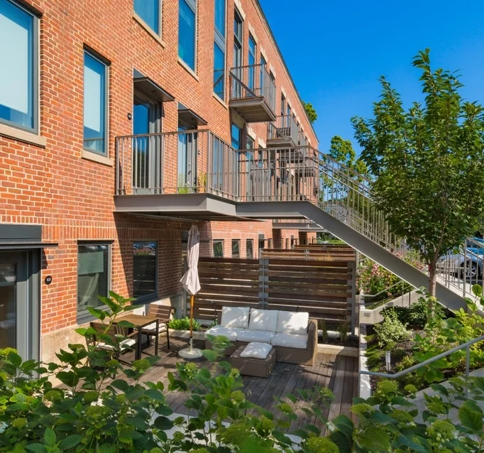 The Wyeth Project Description The development of The Wyeth located at 120 and 124 Rindge Avenue in Cambridge, MA is meets the requirements for certification for USGBC’s LEED for Housing at the Platinum level. The site includes an irrigation cistern, car charging stations and bike racks to contribute to the anticipated certification. The work includes overall site planning and design as well as courtyard design for individual units on the ground floor. Upon entering the site, the curved entry drive allows filtered views into the residential community from the street. A large front lawn is bordered by a garden planting that creates a serene space reflective of the site’s religious past while acting as a privacy buffer for neighbors. The old brick buildings have main entrances to access the second and third floor units on either end of the building. Plantings and custom wood screens create privacy between the courtyards and overall site circulation omitting the need for a railing along the narrow sidewalk. The wood screen with a low planter, and a wood deck are designed to soften the masonry building and create a private outdoor space for unit occupants. *Work completed while working at Crosby | Schlessinger | Smallridge. Architect: Touloukian Touloukian Inc. Civil Engineer: BSC Group Client: Broder Brothers *Image credit Anton Grassl