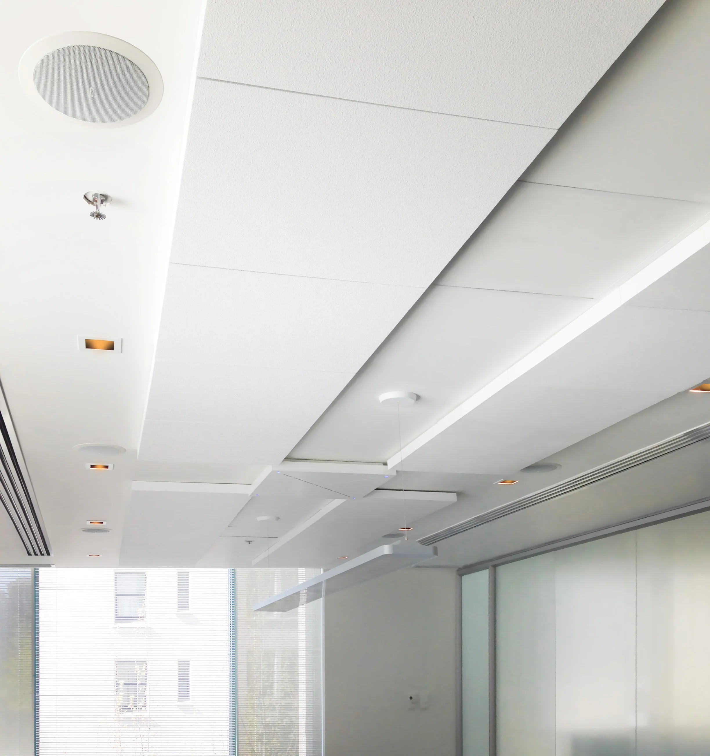 To improve acoustics in this relatively reflective meeting room, we added absorptive acoustic tiling to the ceilings, with a pair of beamforming microphones interleaved within them.