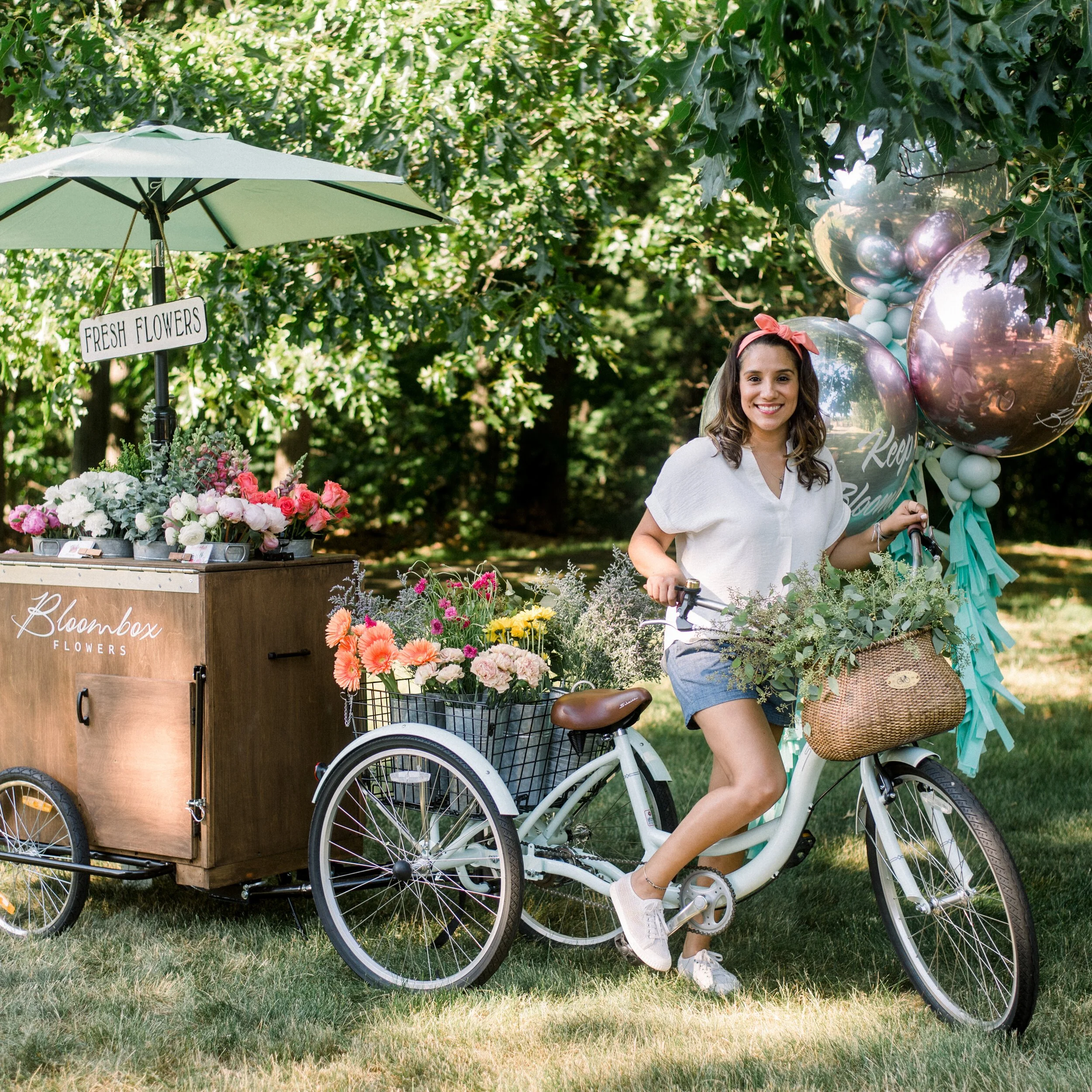 Bloombox Flowers owner on bicycle with flower arrangements in Montclair NJ