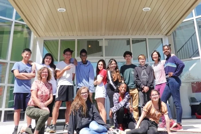 The Grade 8 class poses with Mrs. Barb Ubbens in front of Timothy Christian School, located at 28 Elmhurst Drive in Etobicoke.