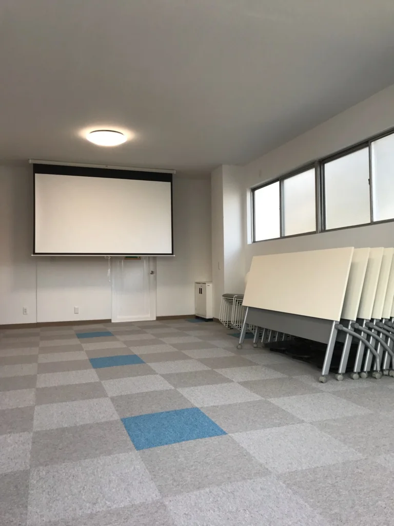 【2階会議室】プロジェクター&スクリーンは無料で貸出しております。テーブルは8台、イスは30脚ご用意しております。