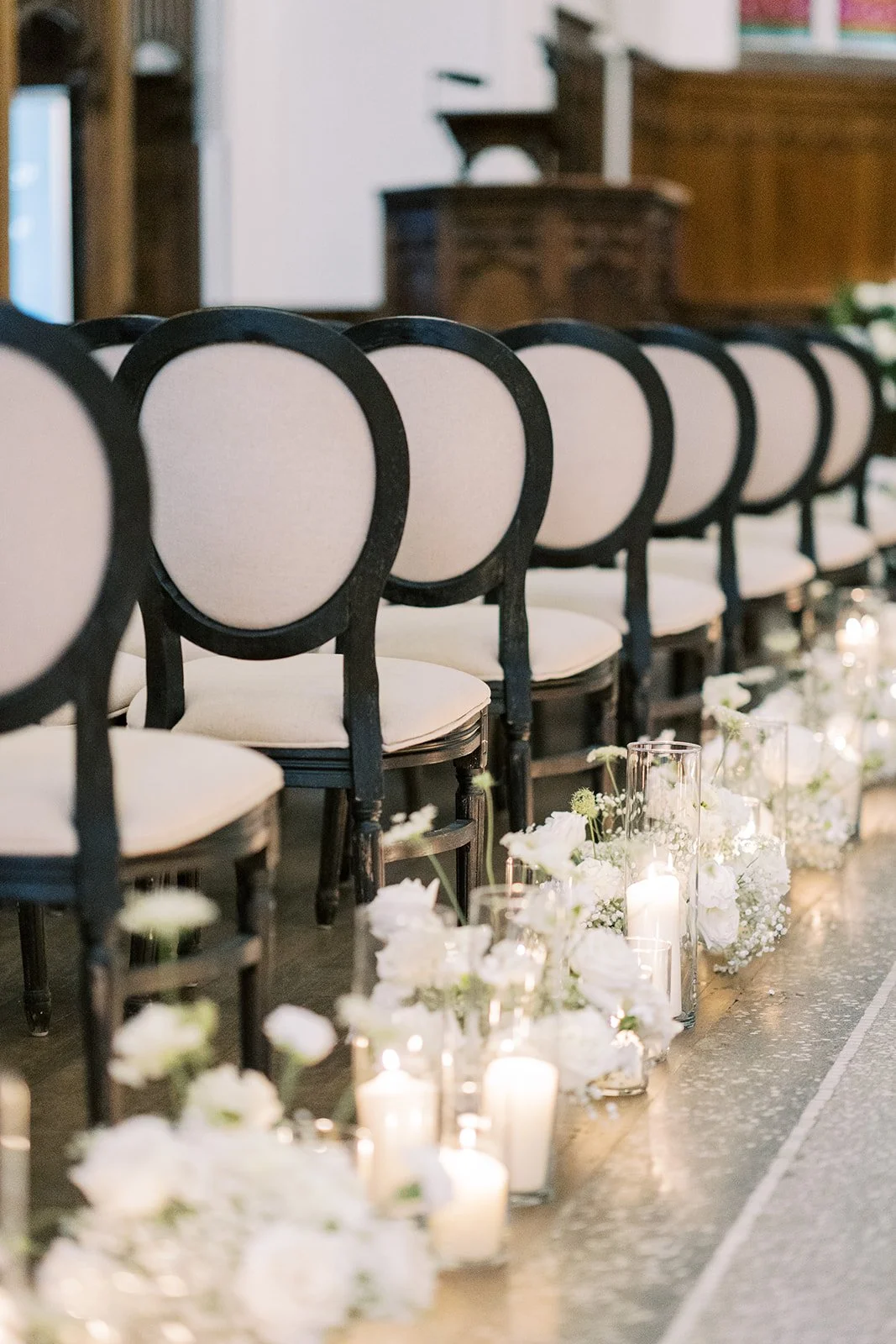 Elegant wedding ceremony seating with floral arrangements inside The Abbey at St. James 1868.