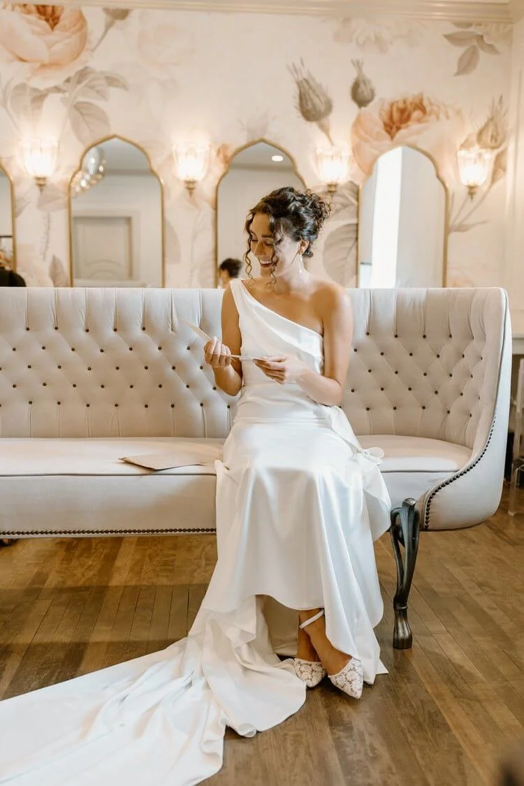 Bride opening a gift while getting ready in the Duchess Suite at St. James 1868.