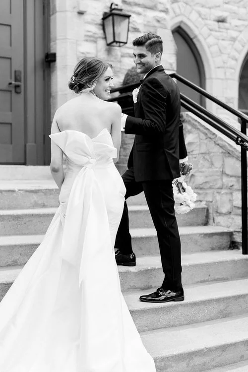 Bride and groom walking up the steps at St. James 1868