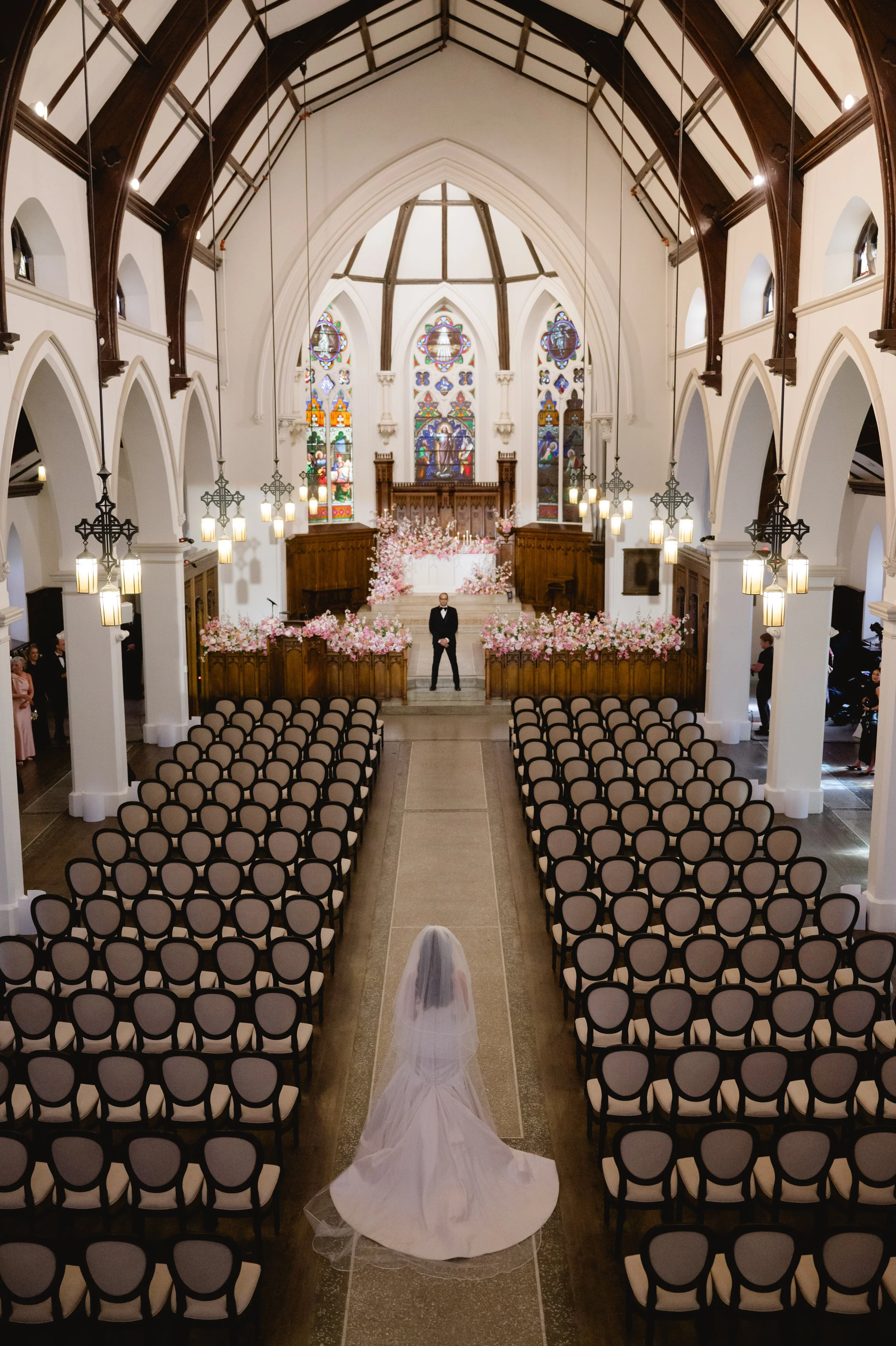 Bride walking down the aisle during a wedding ceremony inside The Abbey at St. James 1868.