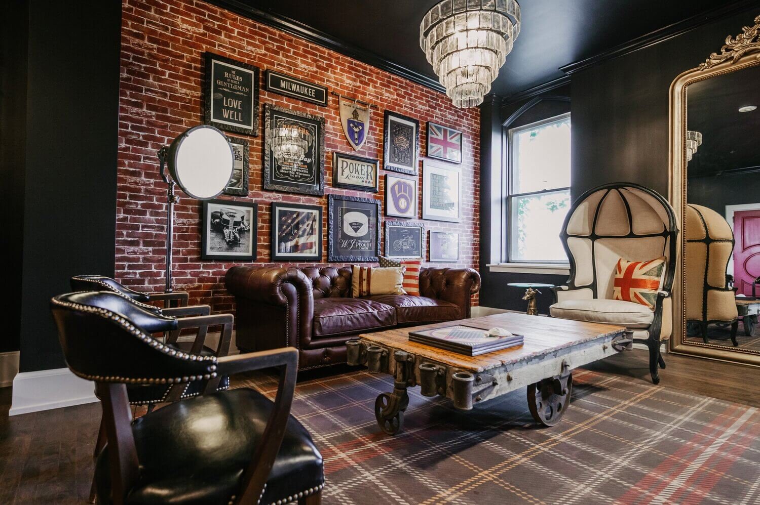 Duke Suite groomsmen getting ready space featuring lounge seating, wall art, and a relaxed English sitting area.