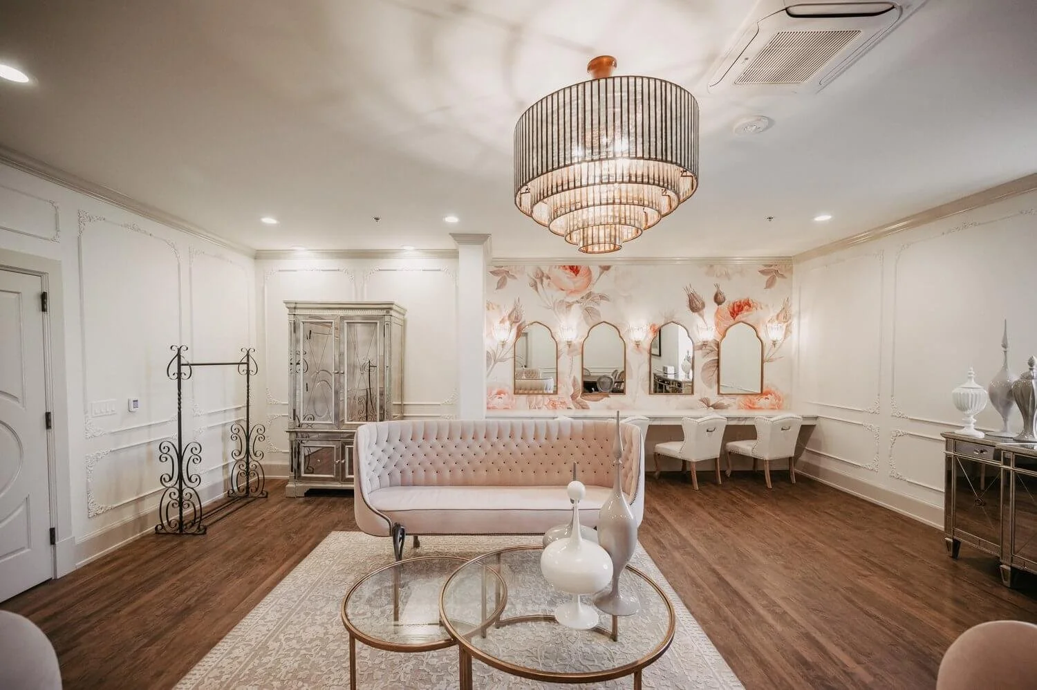 Duchess Suite bridal getting ready space featuring velvet sofas, chandelier, and stylist stations.