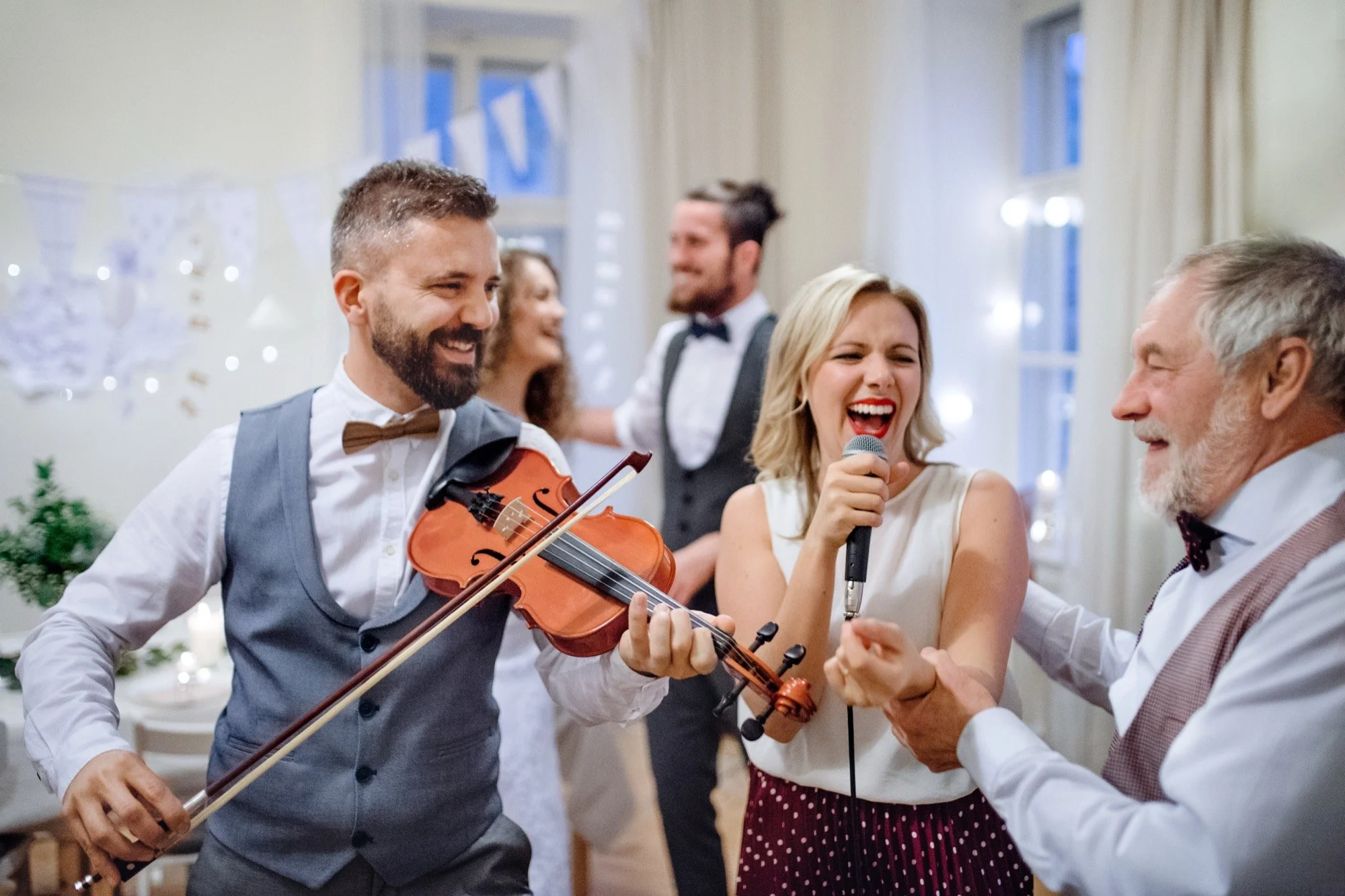 Bride, groom, and guests dancing at a wedding reception