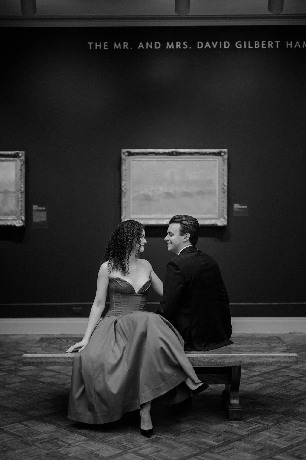 Chicago engagement photos in black and white, with a couple kissing between two marble columns at the Art Institute