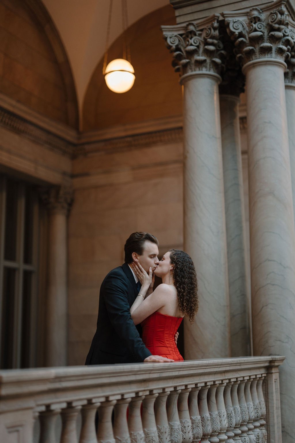Couple kissing on a marble balcony with Corinthian columns inside the Art Institute of Chicago