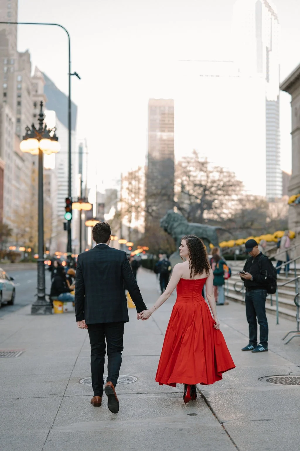 Chicago engagement photos in black and white, with a couple crossing a downtown Chicago street as she looks back at the camera