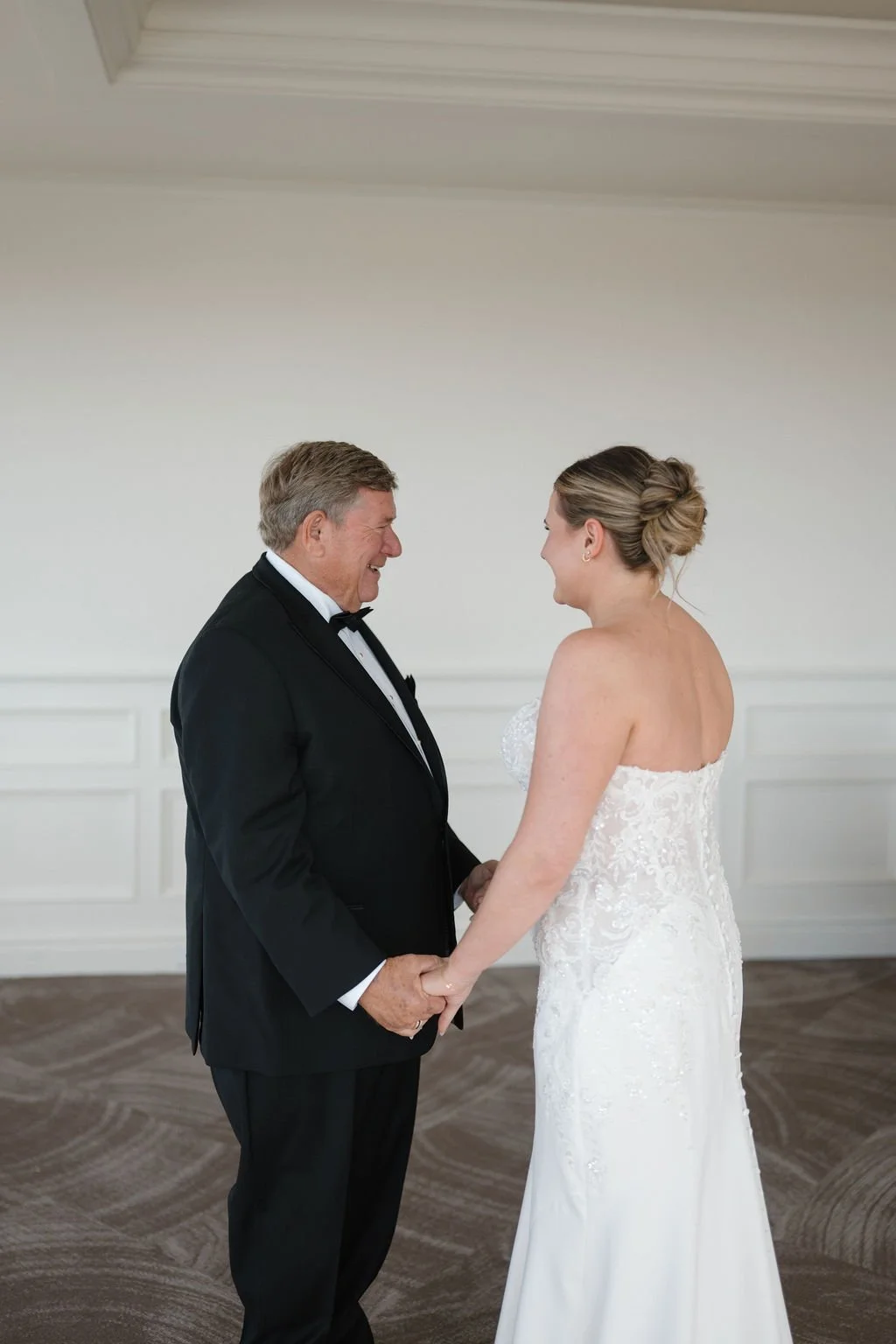 Emotional father-daughter first look between a bride in a lace gown and her dad in a tuxedo at one of the Fort Wayne wedding venues
