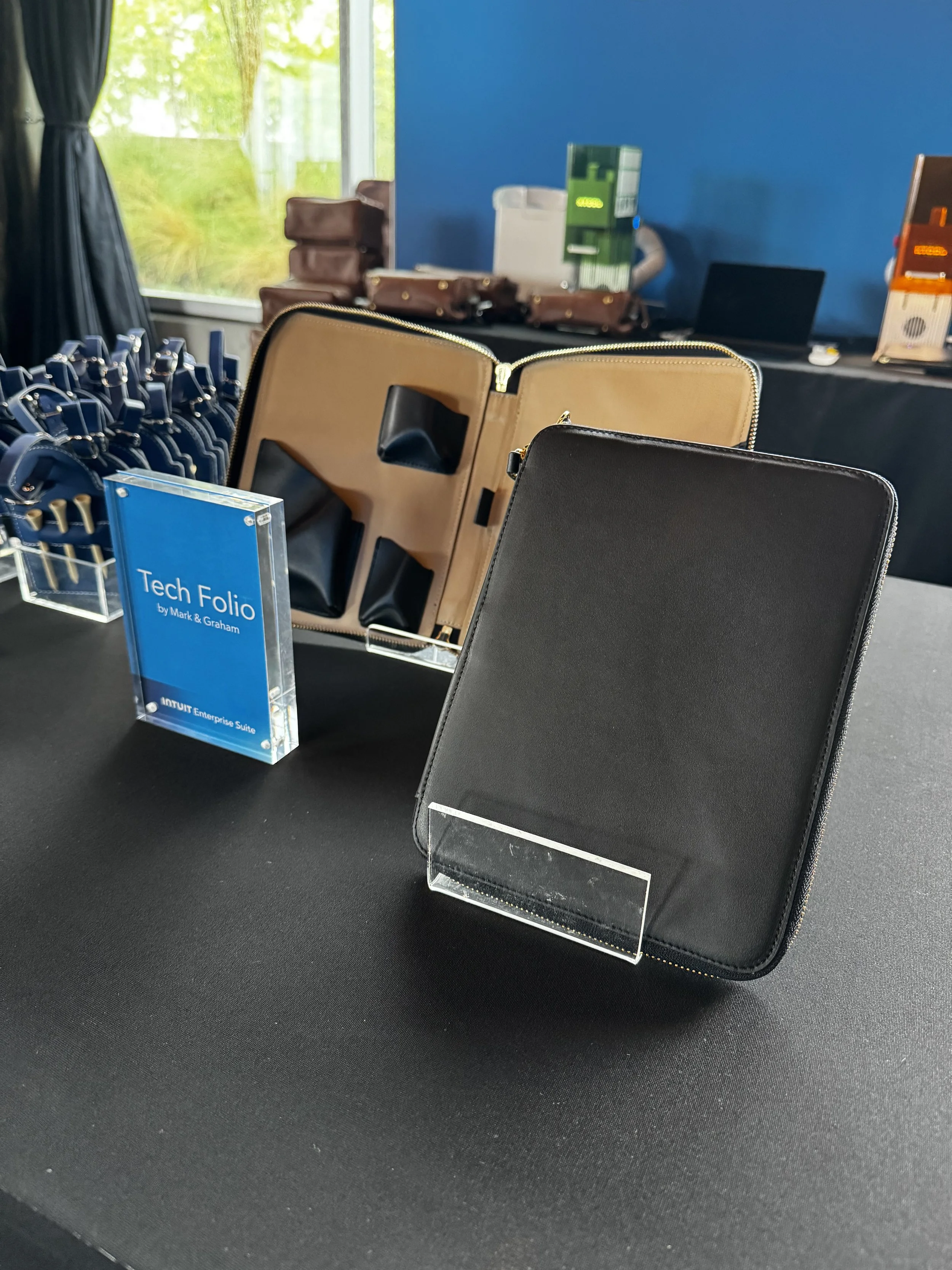 Display showing the leather tech folio available to be laser engraved live on site at intuit client event