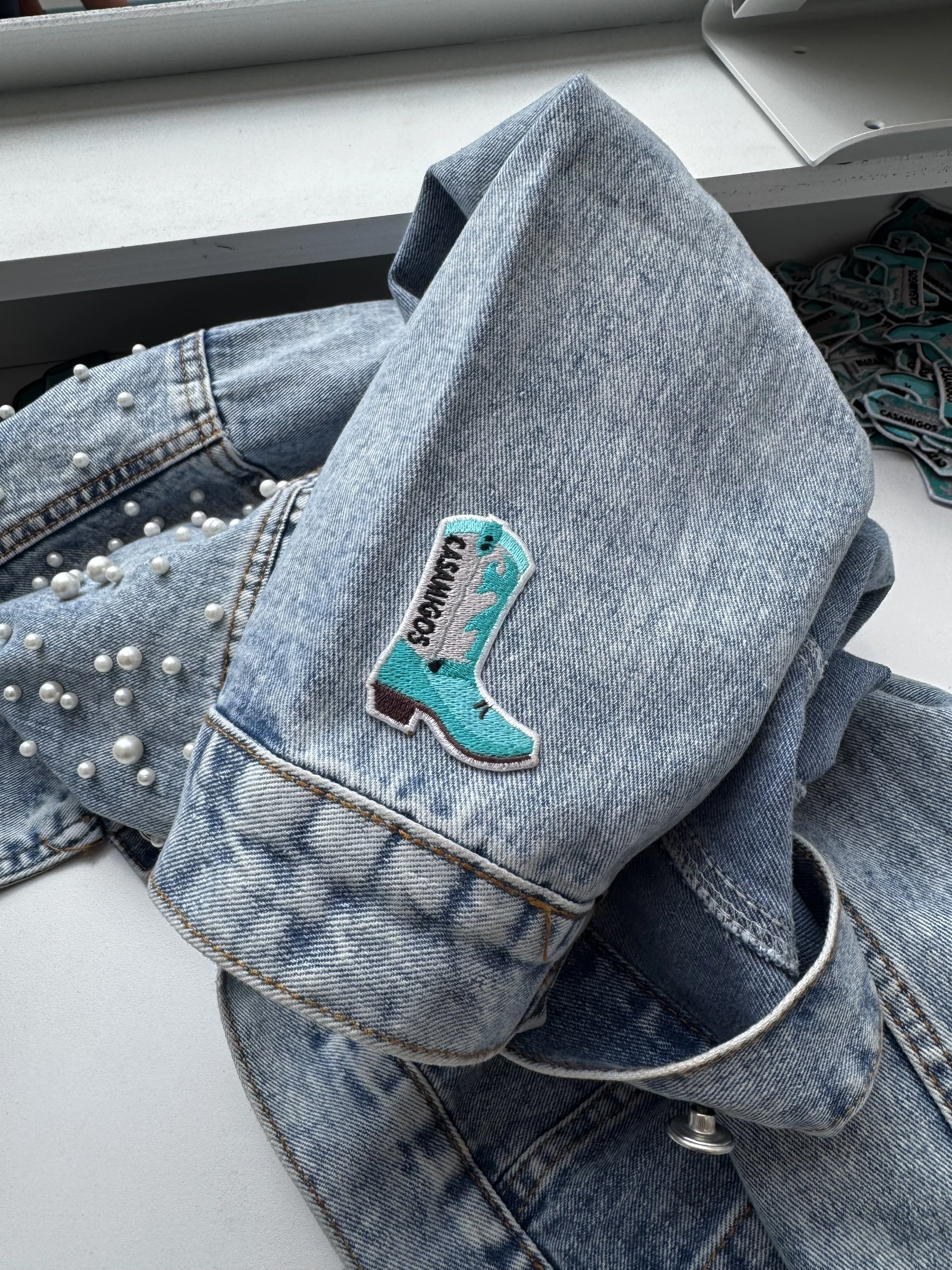 Cowboy boot patch on denim jacket at Casamigos live heat press activation.