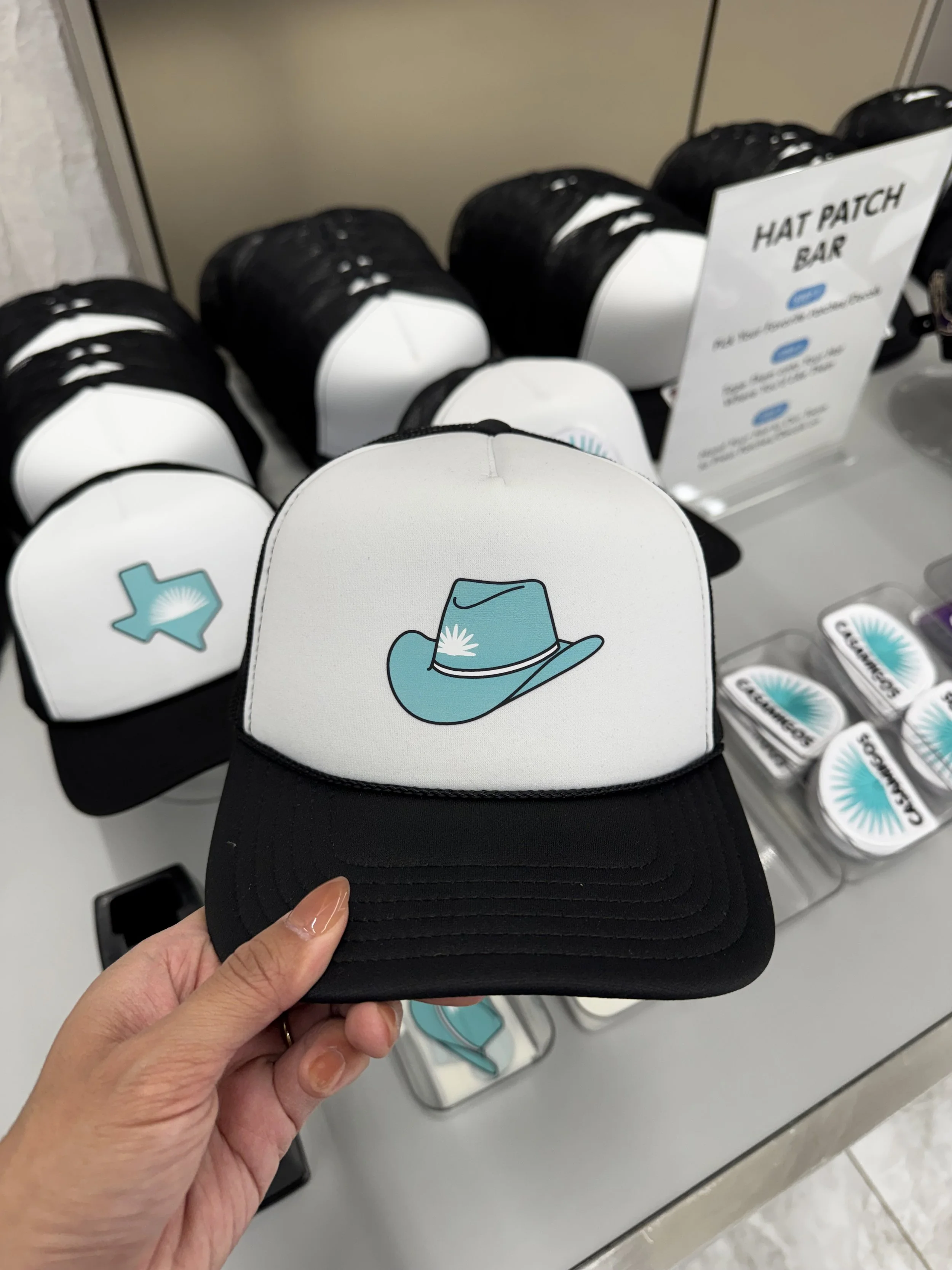 Cowboy hat in Casamigos colors heat pressed onto trucker hat live at event at Dallas Cowboy's stadium