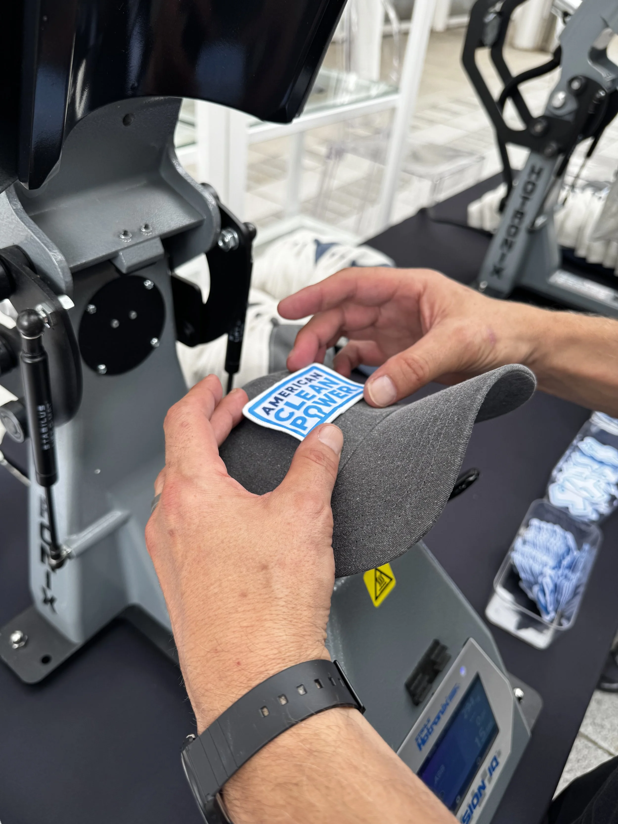 Showing custom patch being applied before heat press uses heat and pressure to permanently affix the patch to the garment