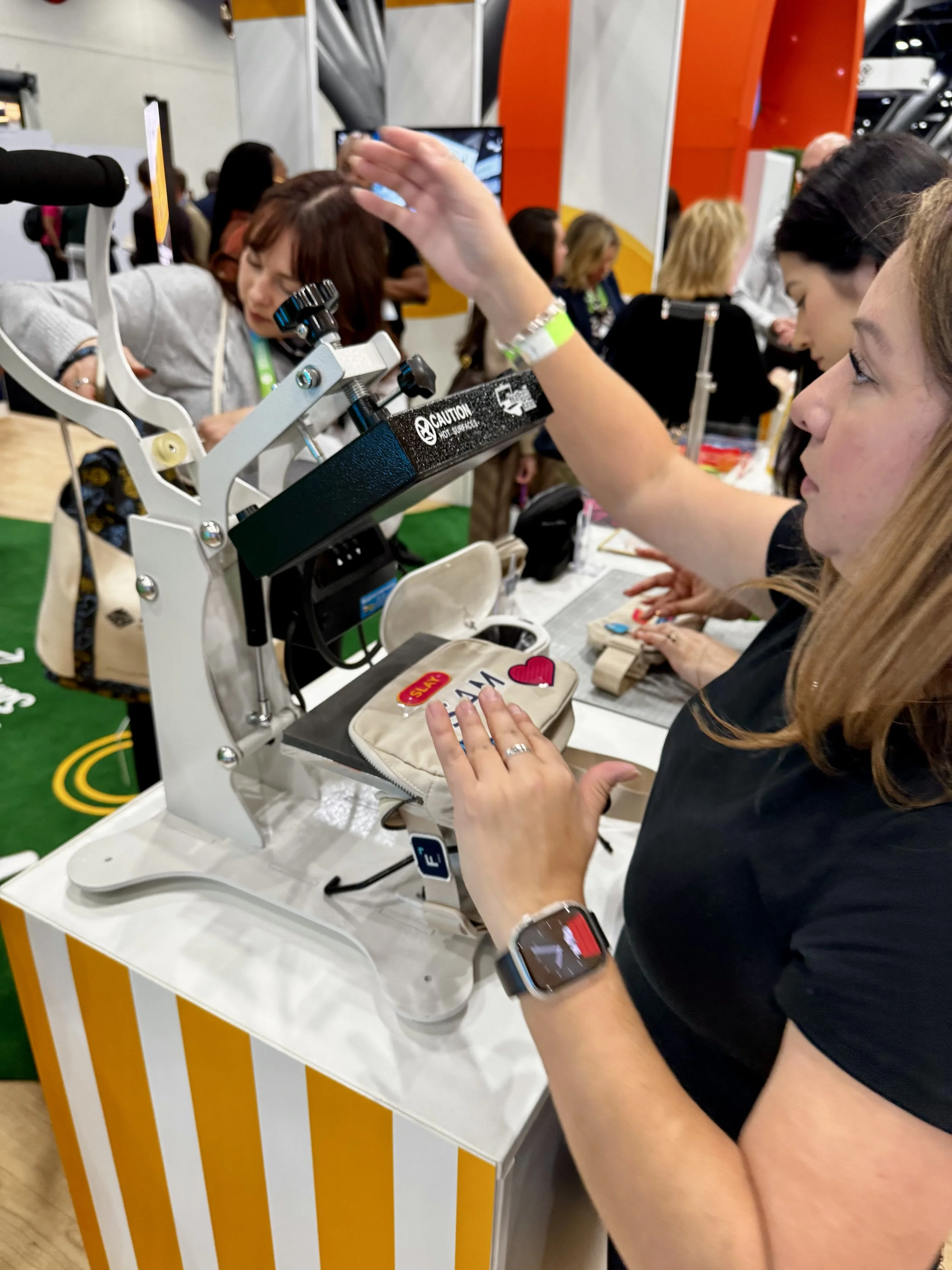 Apdat staff operating heat press during live monogramming activation at expo expo 2025