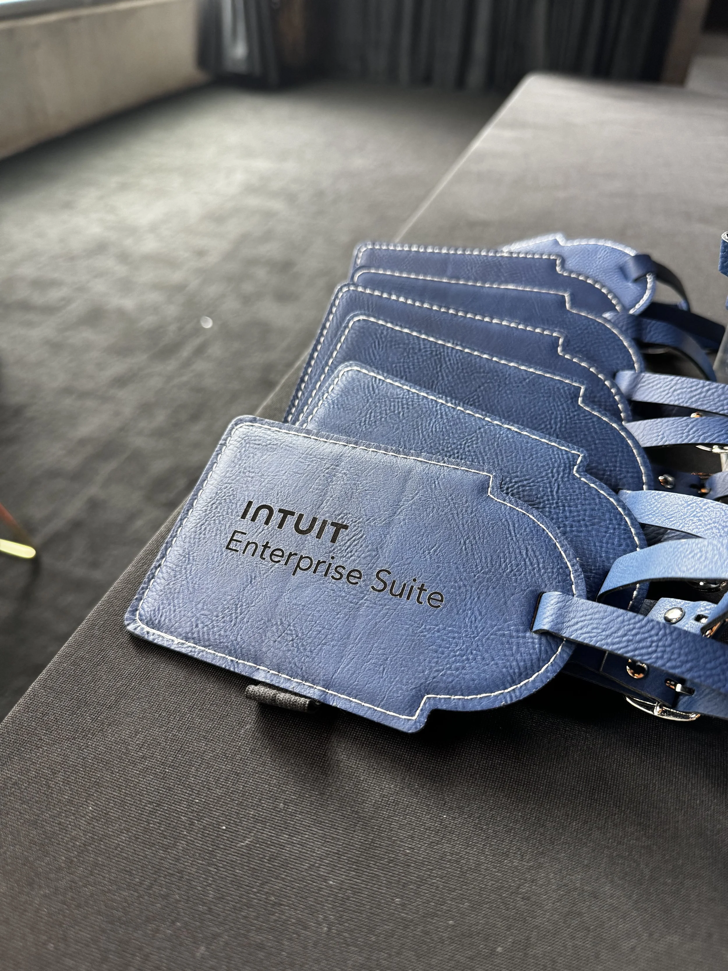 Navy blue leatherette luggage tags engraved with Intuit logo make great client gift