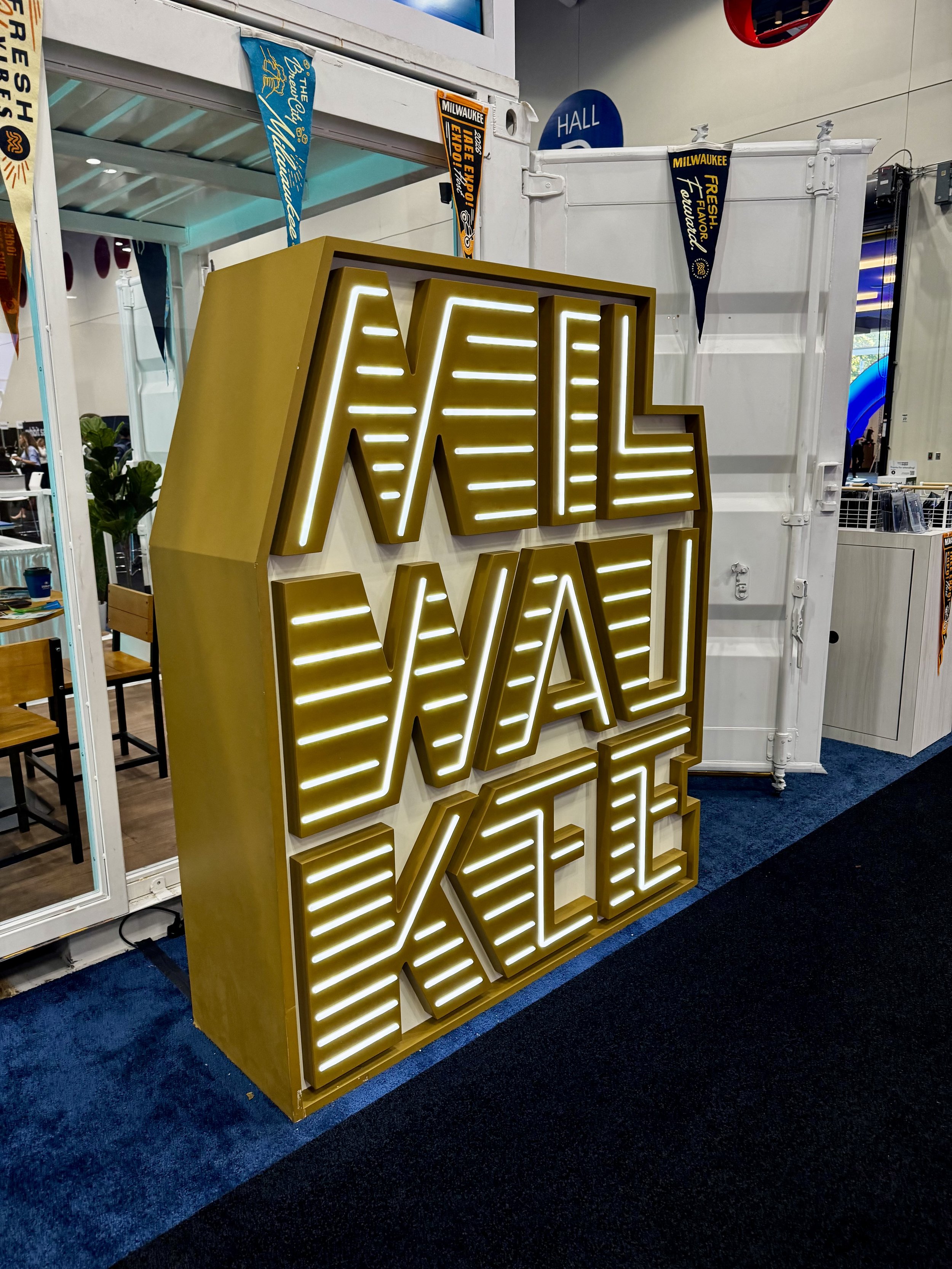 Large golden sign drawing people toward the visit milwaukee booth at expo expo 2025
