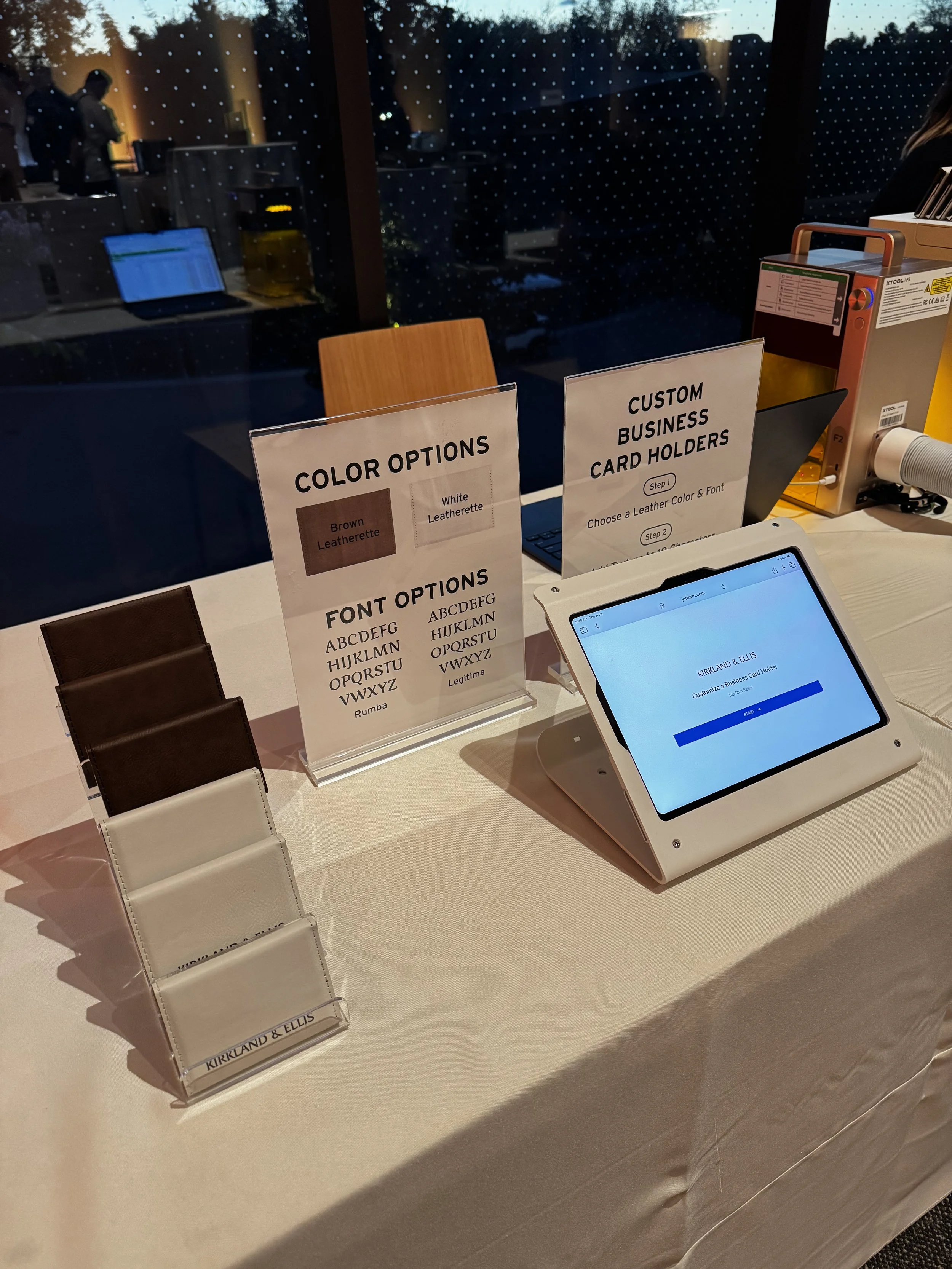 Display examples of business card holders and i pad which guests can fill out order form for live laser engraving