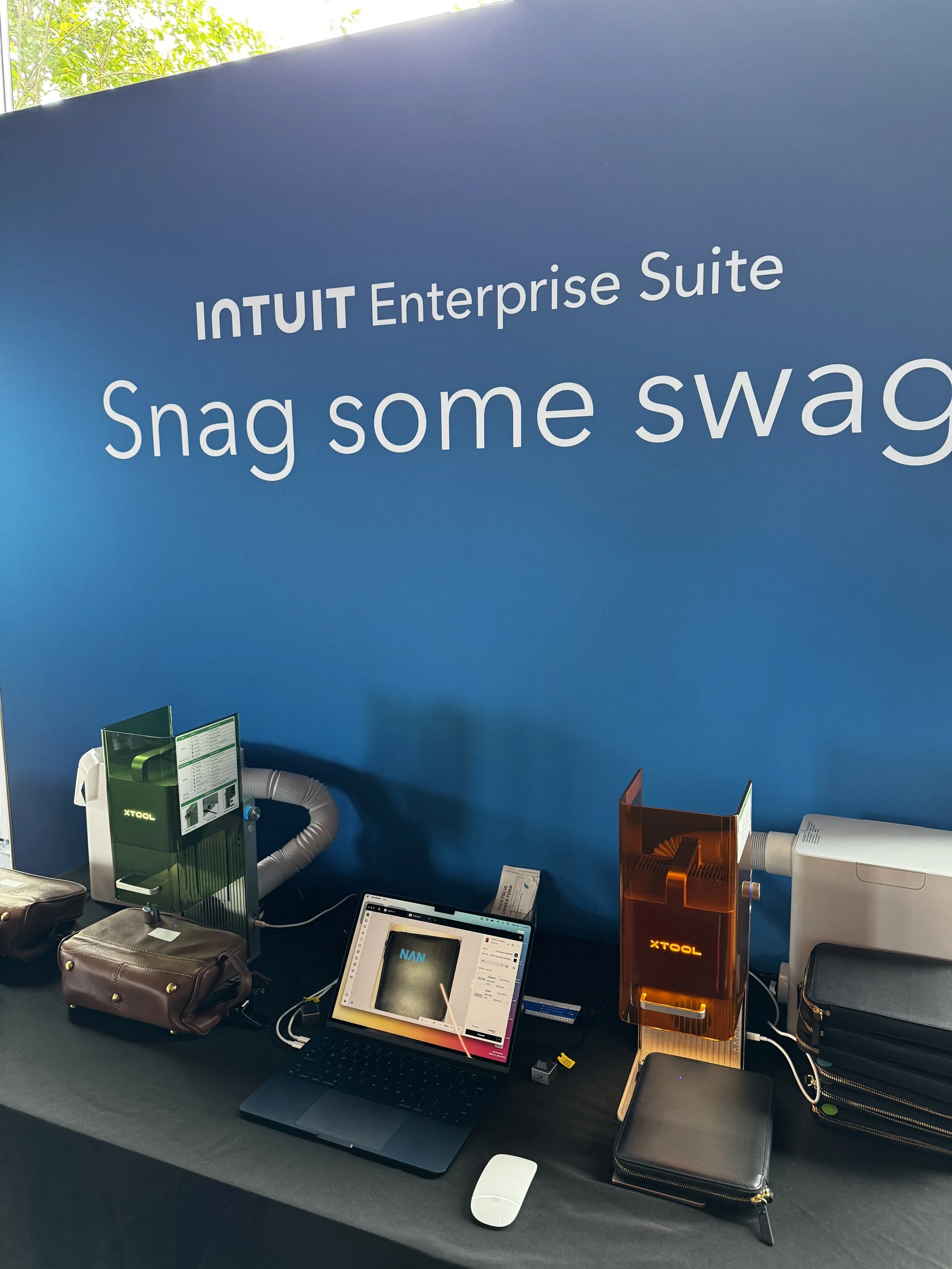 Station showing X-tool laser engraving machines and laptop enabling multiple engraving machines and settings to run at once