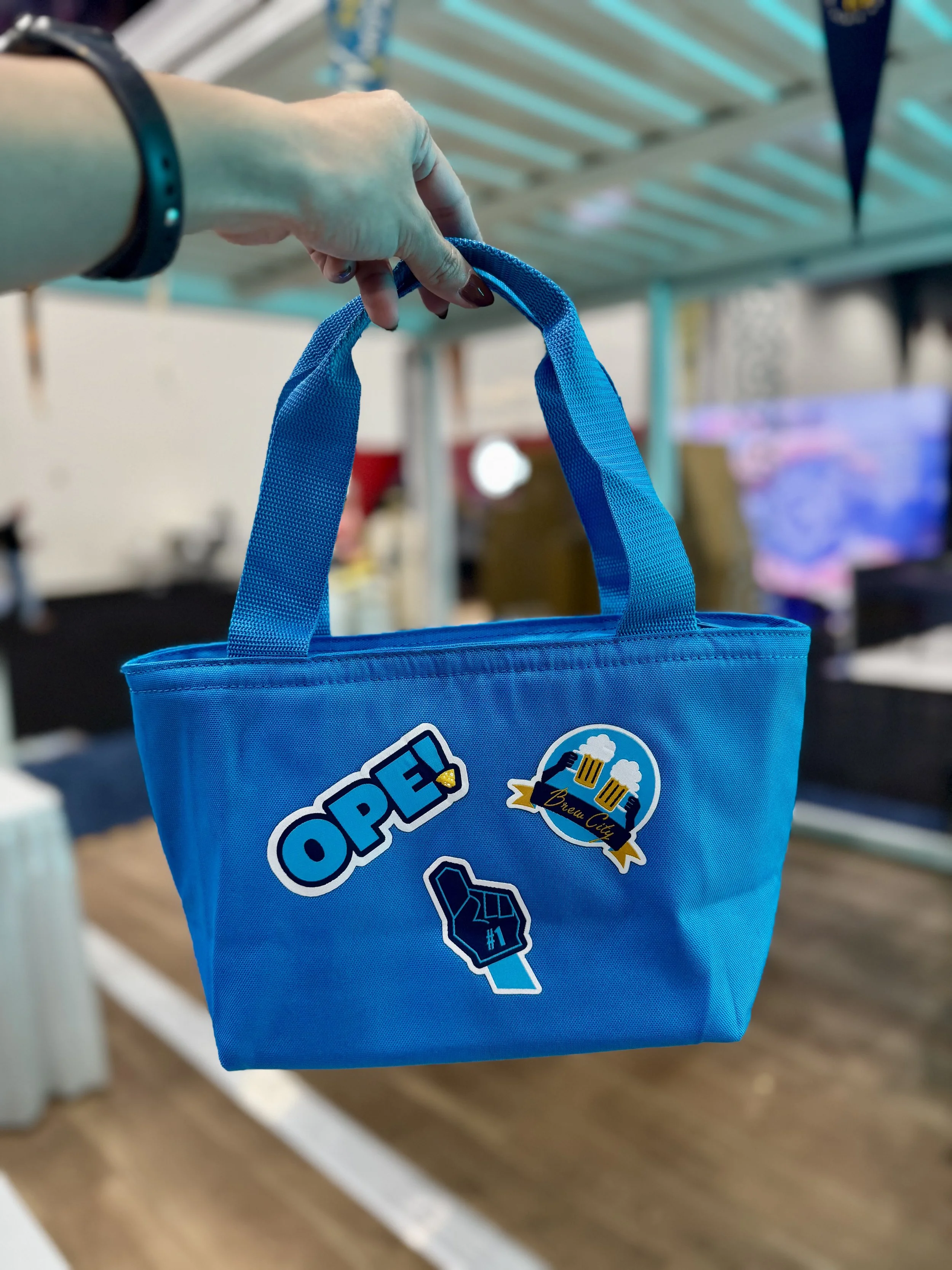 blue mood lighting reflects off blue cooler tote that has been heat pressed live on site at expo expo 2025