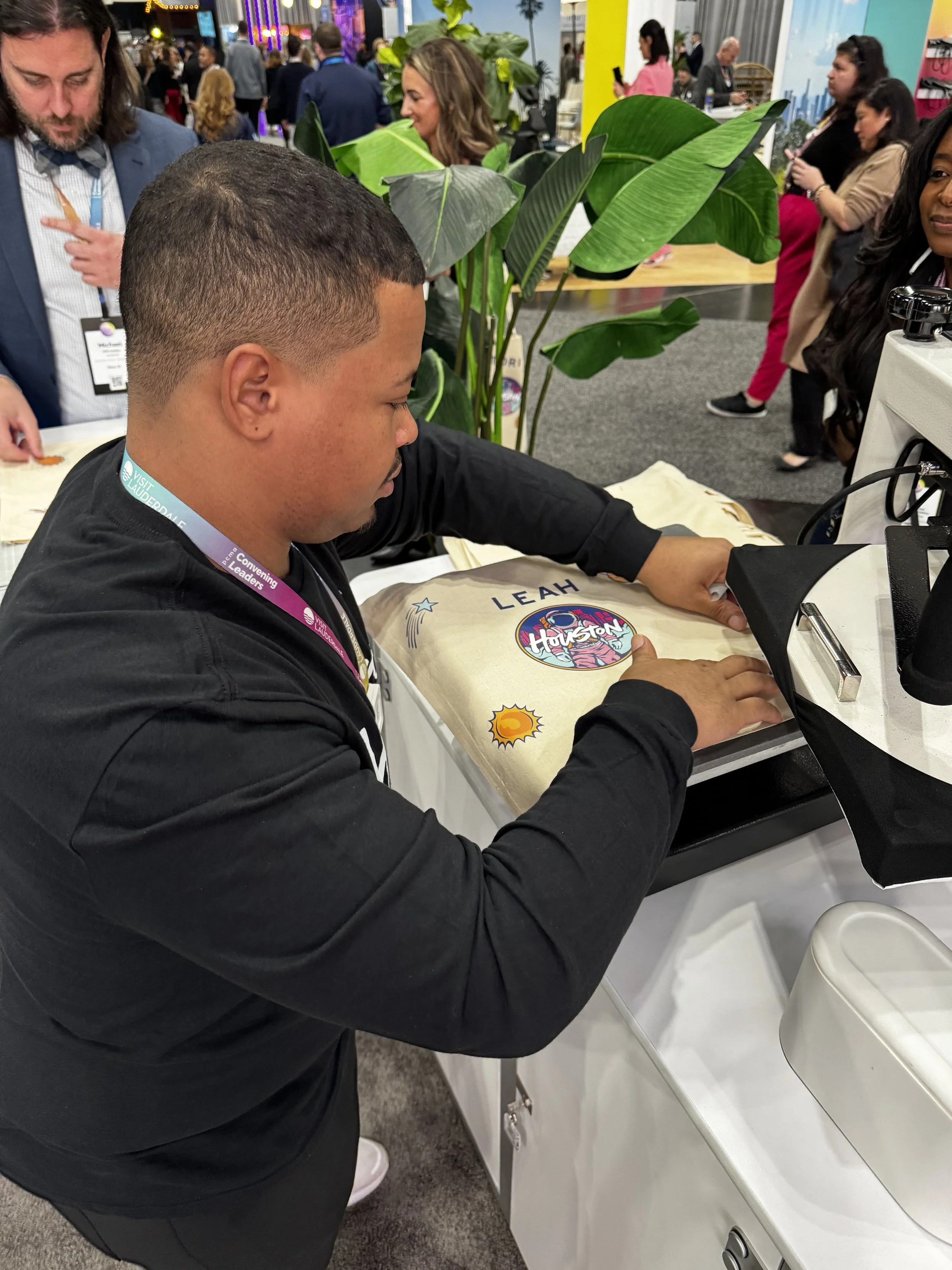 Live heat pressing in action , houston and space themed tote bags and monogrammed letters.