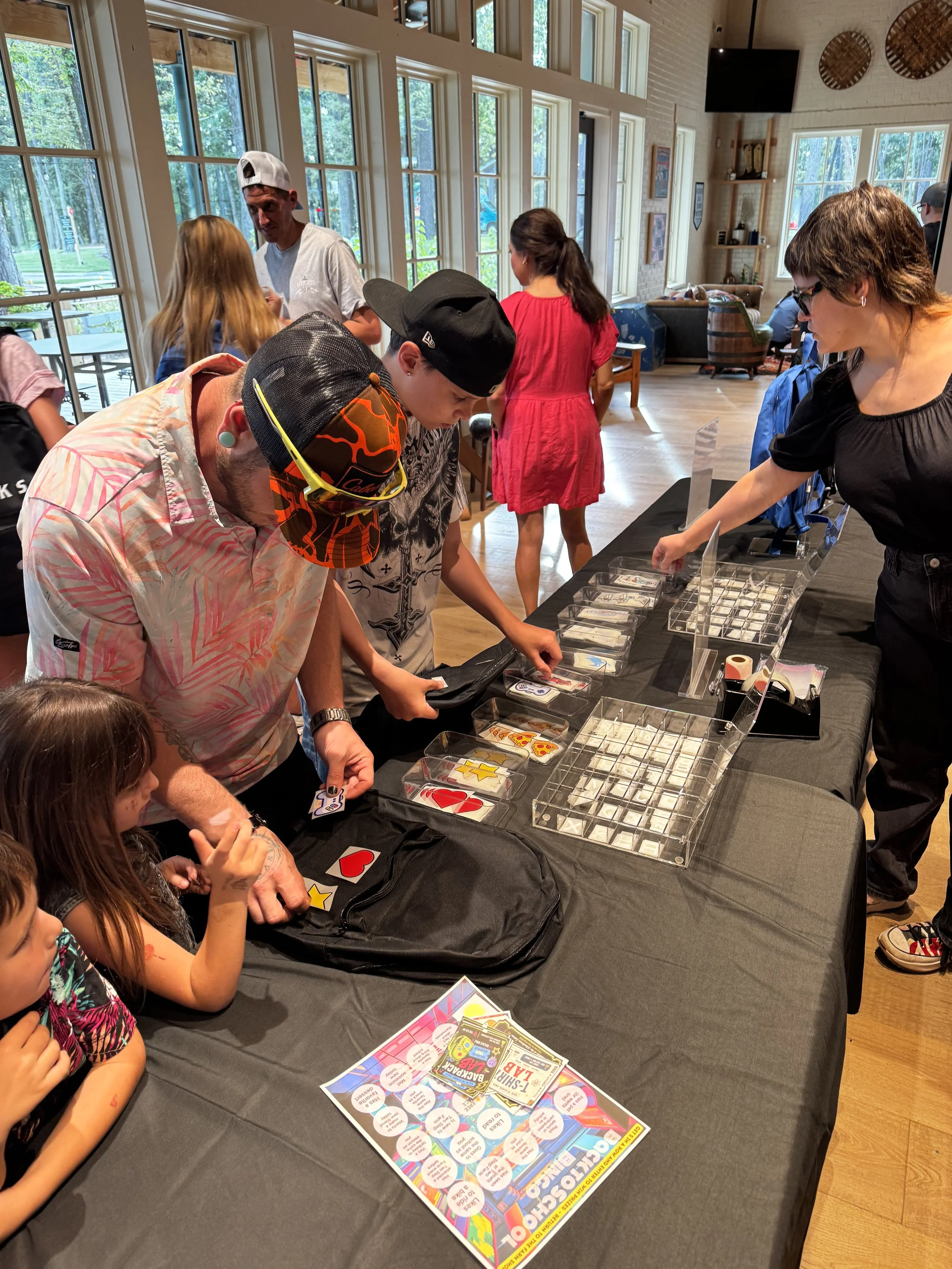 Kids and Parents lining up to arrange their decorations on their new backpacks to give them some style in the new year