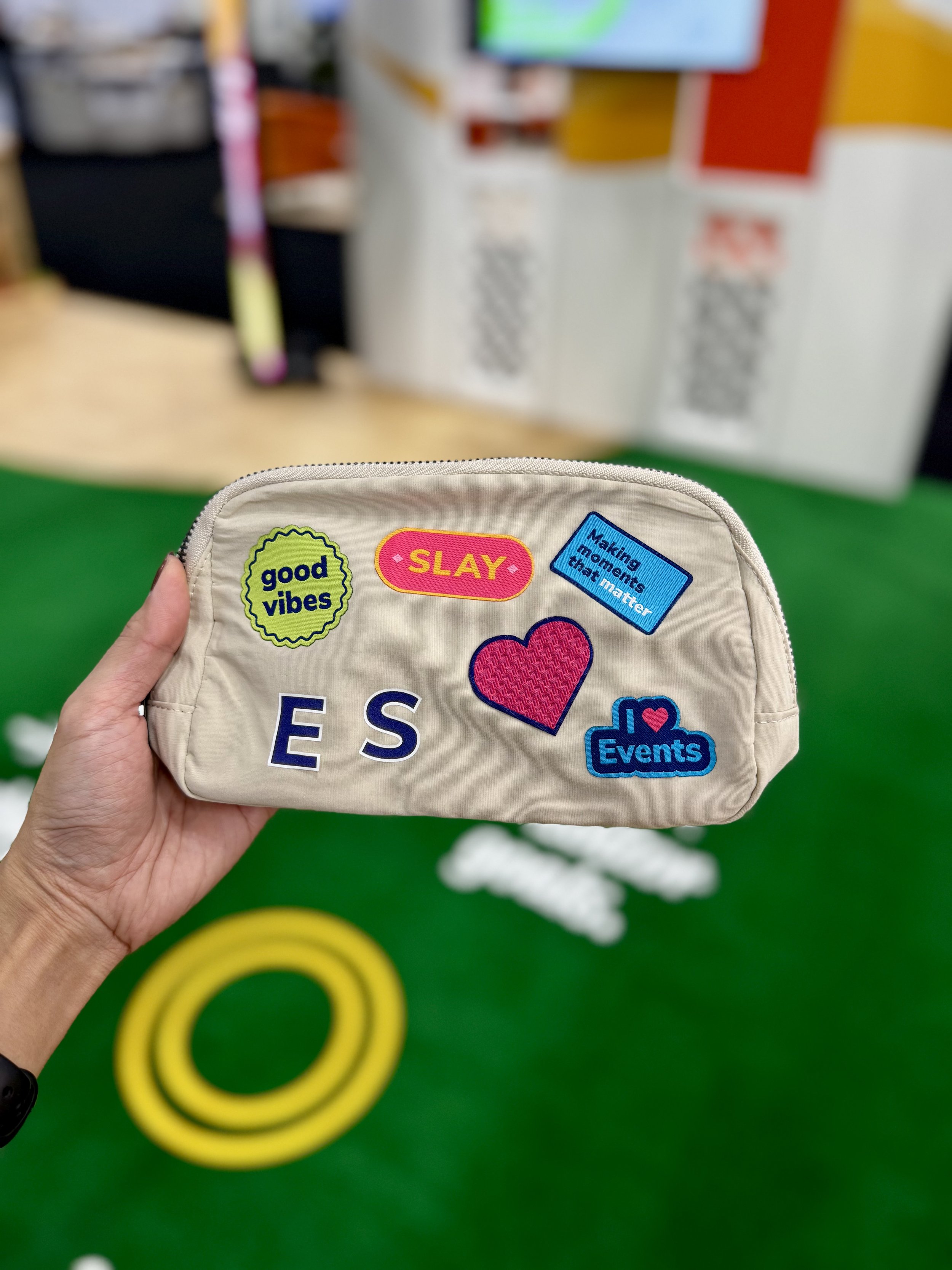 Off white belt bag with multiple colorful woven patches and monogrammed letters heat pressed on live at expo expo