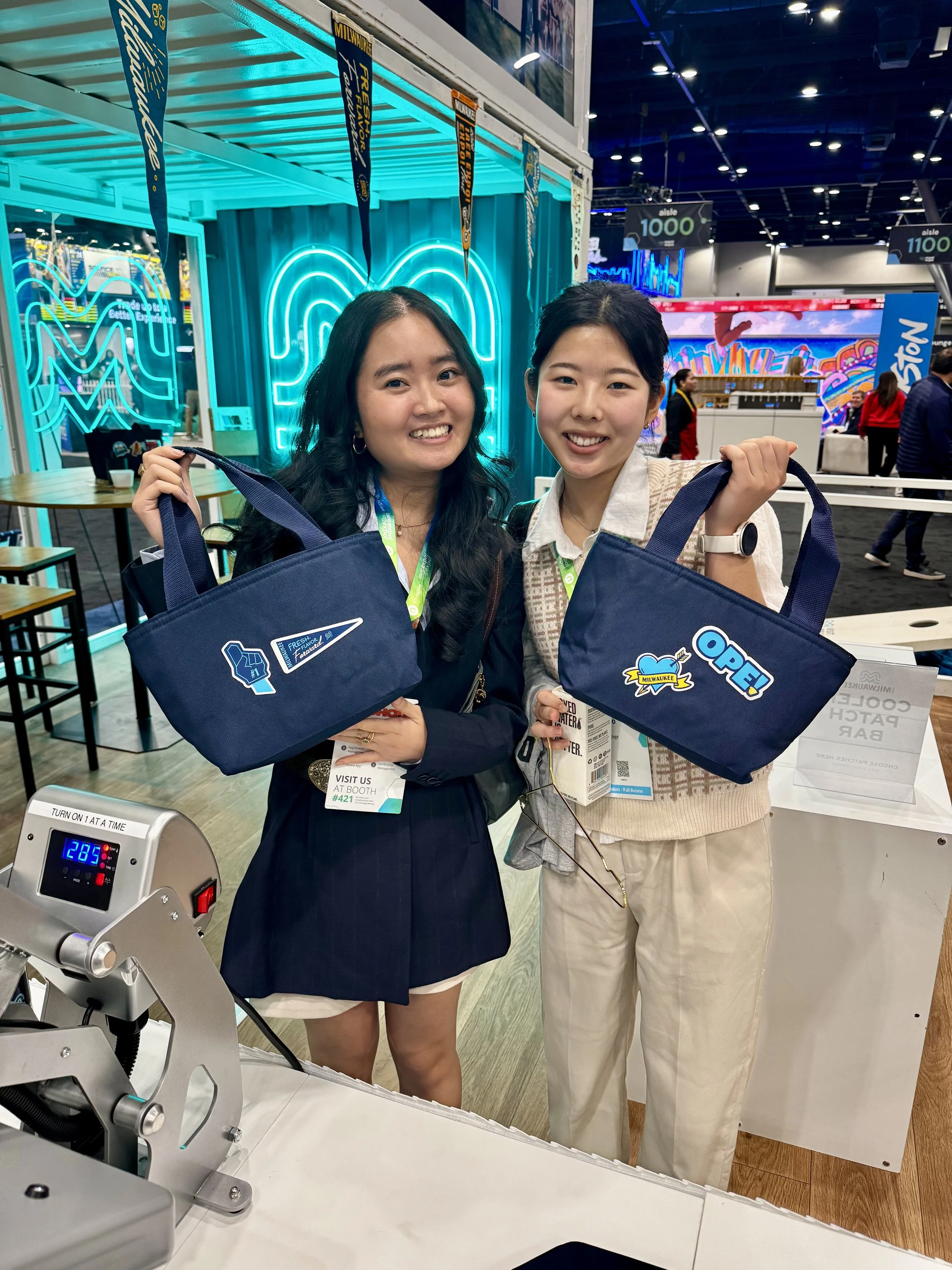 Event attendees model their cooler bags that are hot off the presses