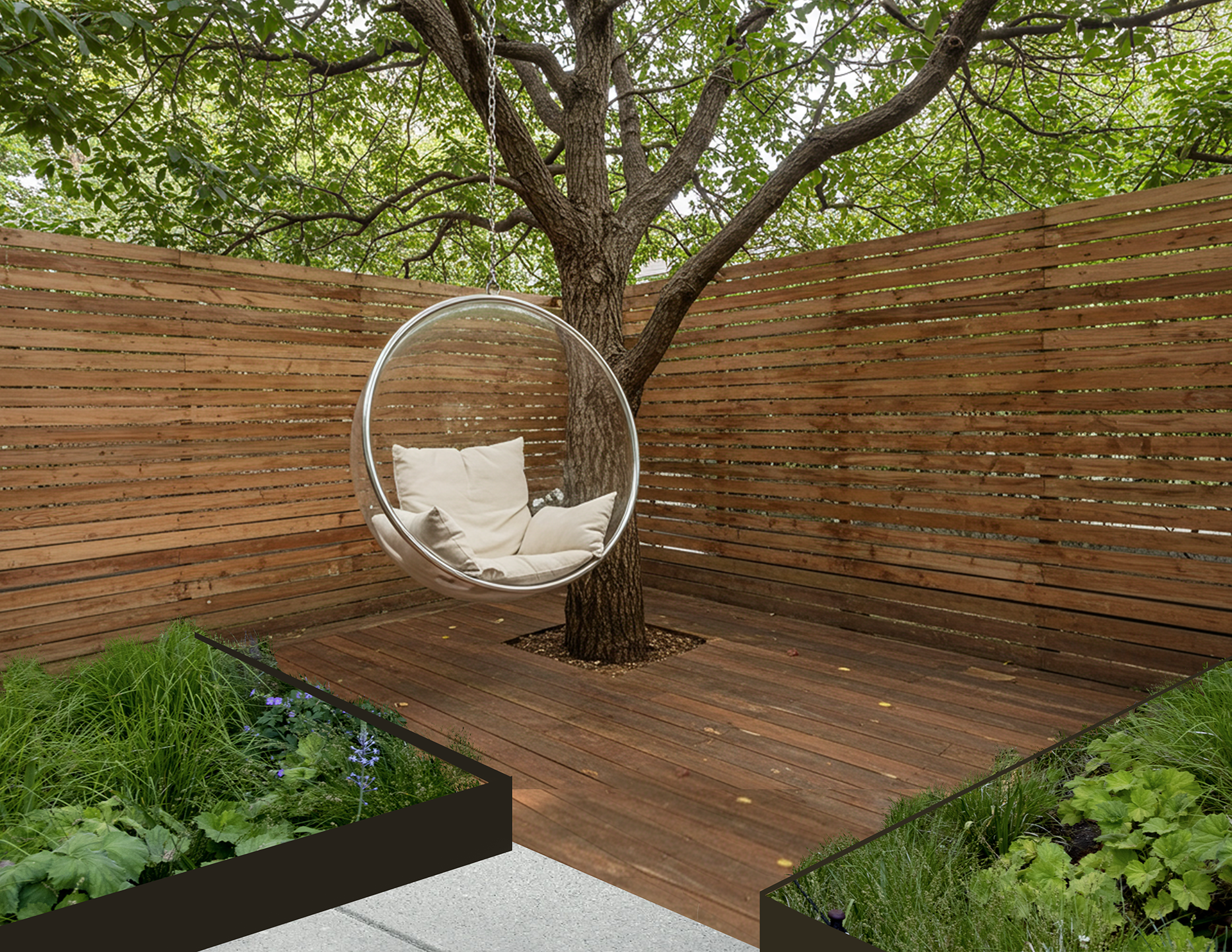 A backyard garden with a wooden deck, a tree with a hanging circular canopy chair with cushions, and raised garden beds with green plants and flowers, enclosed by a wooden slat fence with leafy green trees overhead.