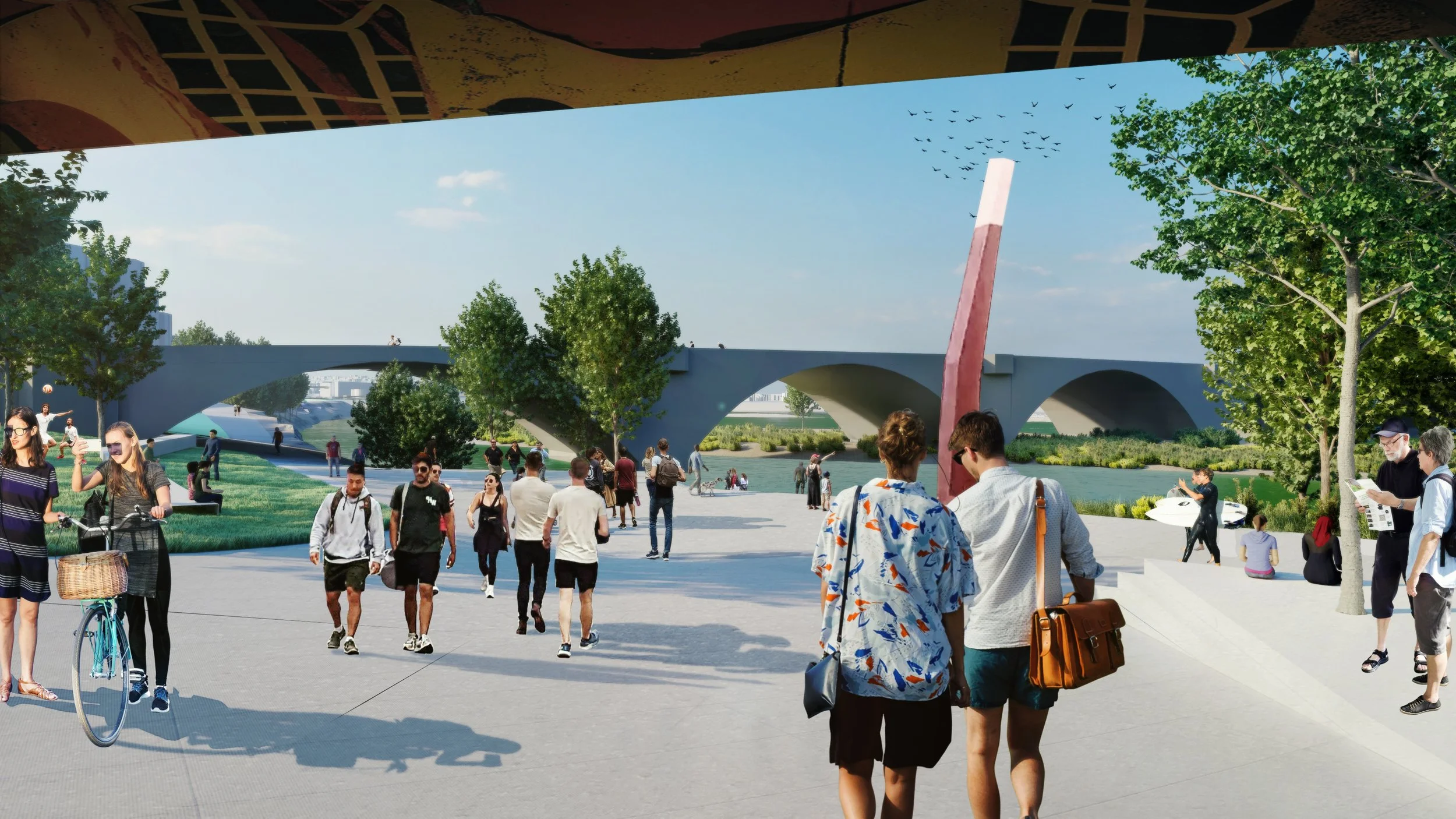 People walking and cycling in a park near a modern bridge on a sunny day.