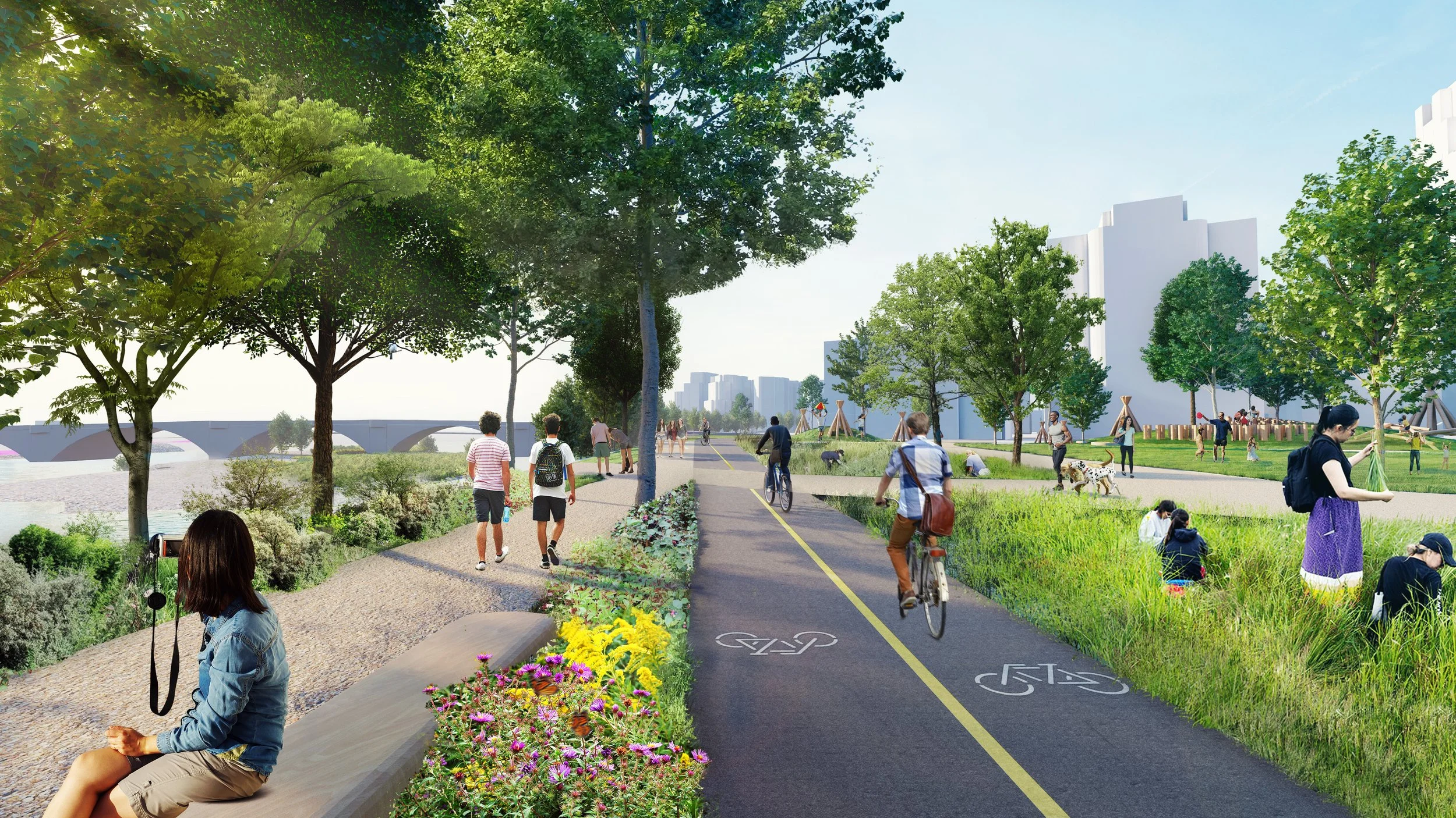 People walking and cycling on a paved path beside a river, with trees, plants, and grassy areas; a bridge in the background and several people enjoying various outdoor activities.