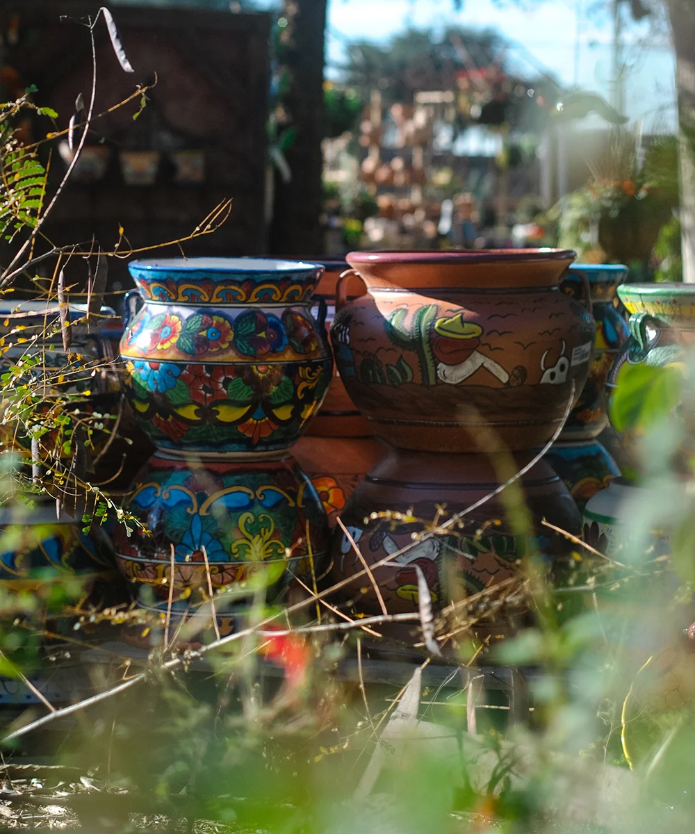 Pictured above are two styles of hand-made Talavera Mexican pottery displayed together at Enchanted Gardens . Our buying staff hand-picks the Talavera out of a wide selection with our customers and local culture in mind. They look for familiar signatures of our favorite artists as well as keep an eye out for new gems.